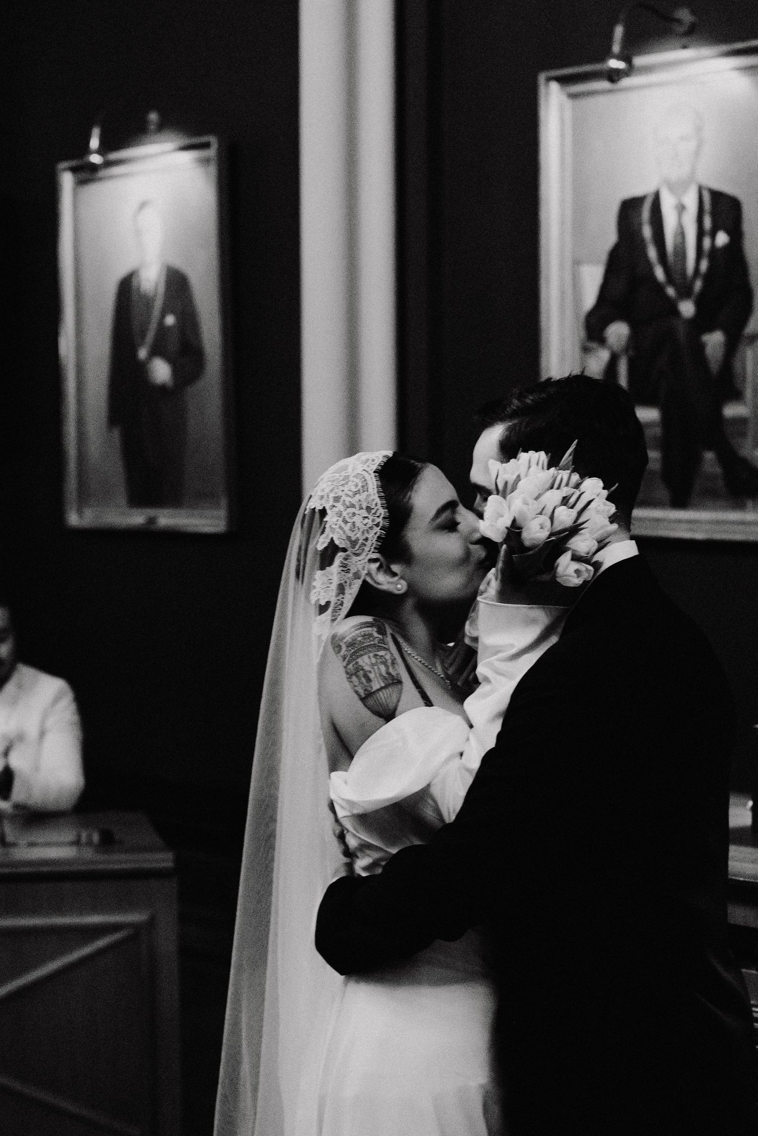 Black and white wedding photo sequence showing couple sharing an intimate moment against dark backdrop.