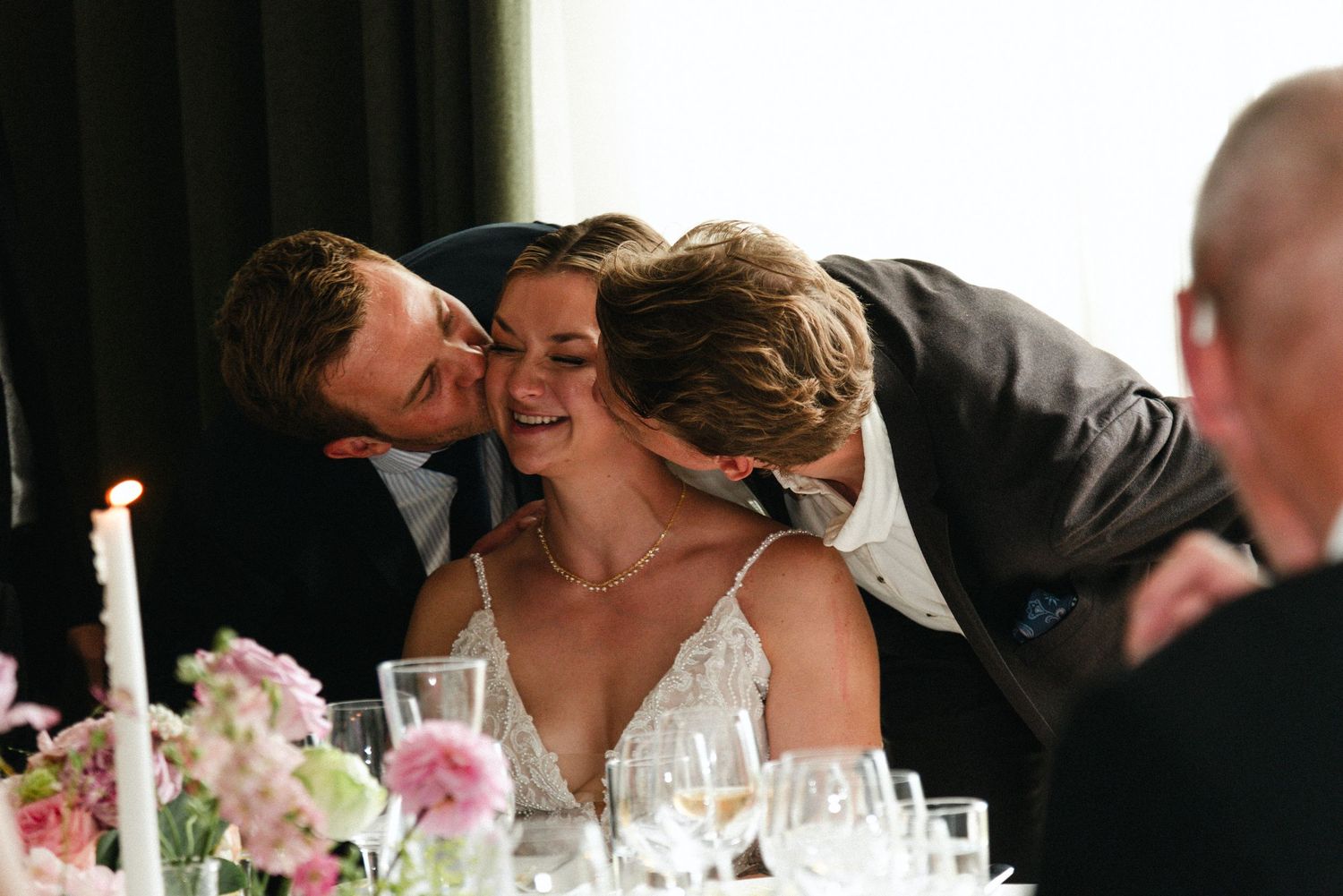 Intimate candlelit wedding reception moment captured at a dining table.