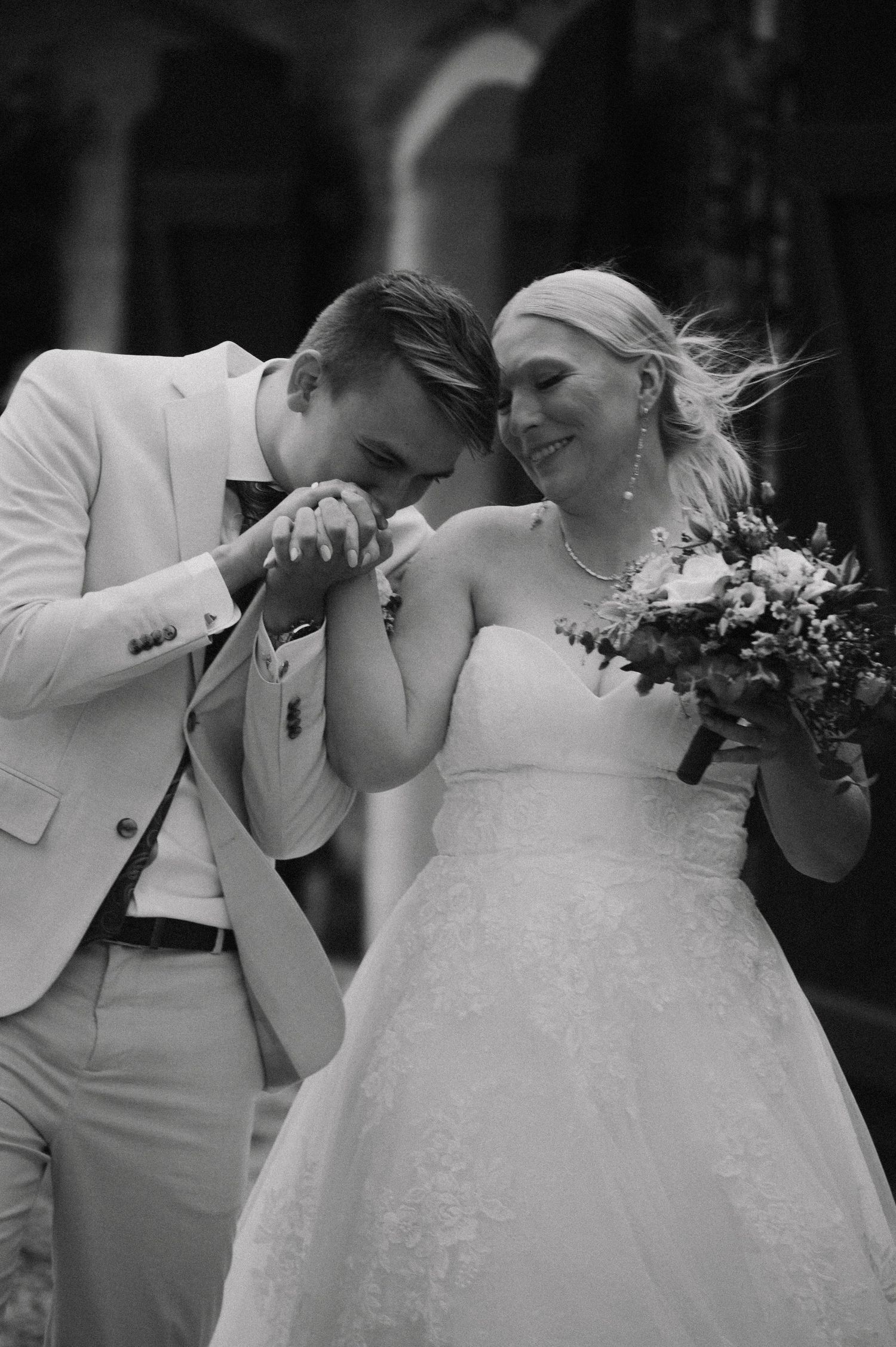 A tender moment between newlyweds sharing laughter in formal attire.