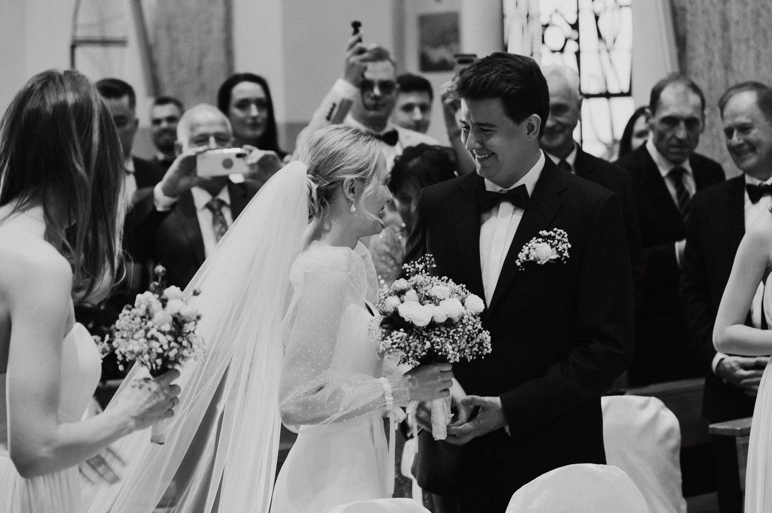 Wedding ceremony guests gathered in formal attire at an elegant chapel.