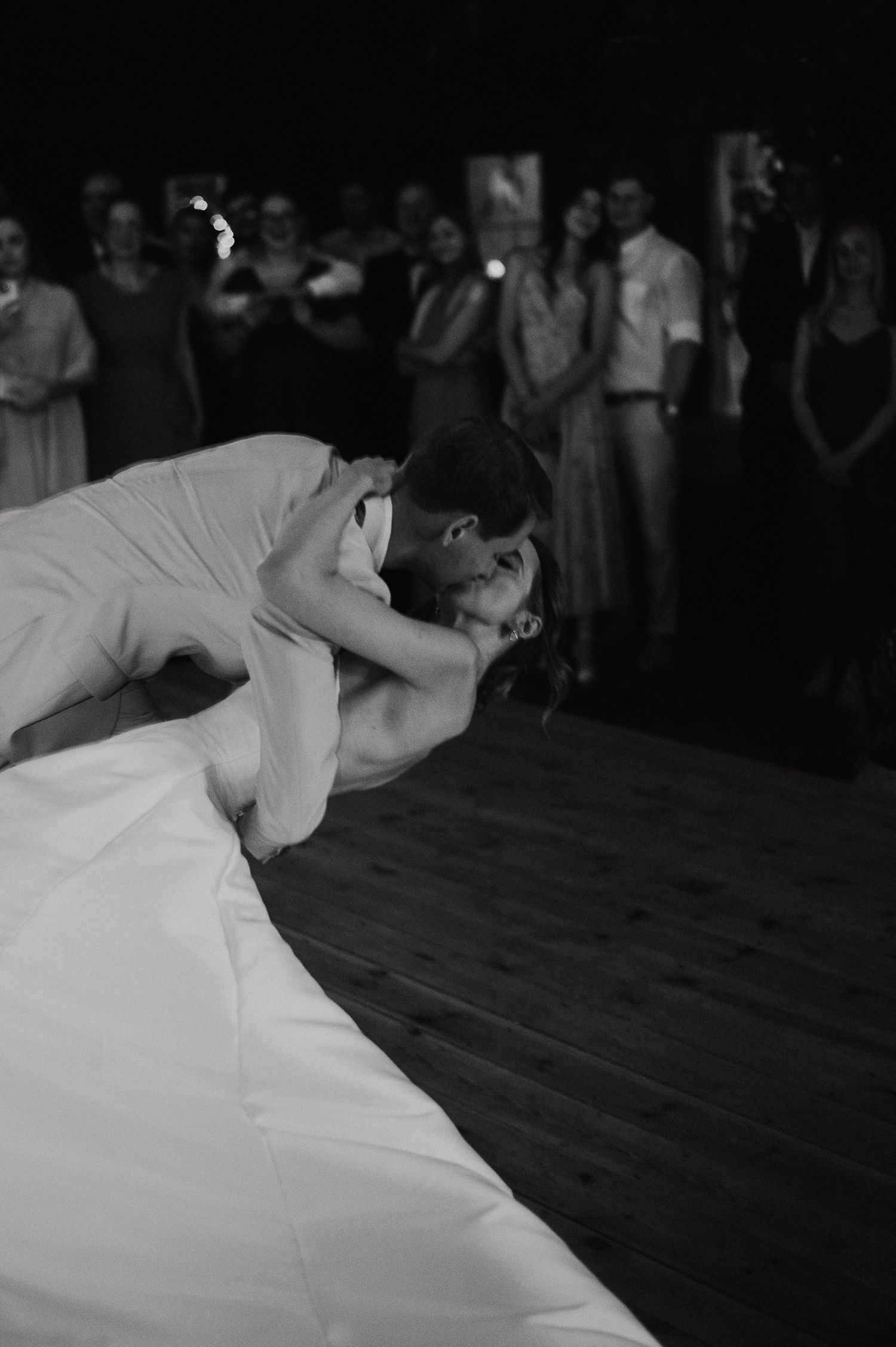 A sequence of dance movements shows a performer in white clothing bending backwards gracefully on a dark floor.