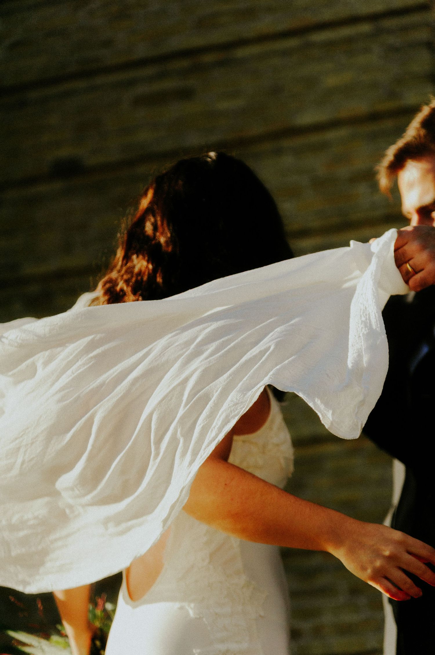 A flowing white wedding dress fabric billows gracefully in the wind creating an ethereal movement effect.
