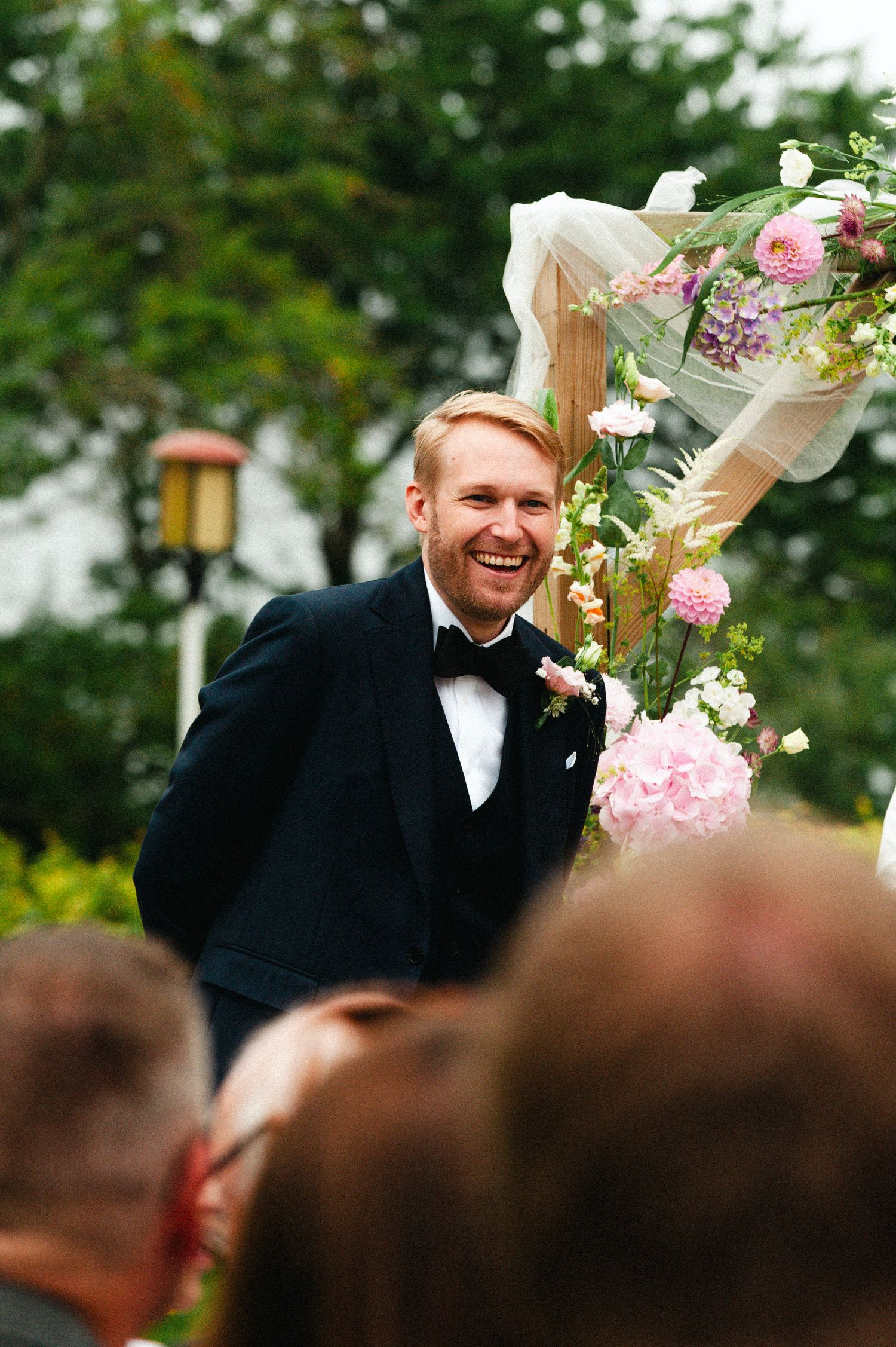 Wedding photo sequence showing joyful reactions during an outdoor ceremony with pink and white flowers.