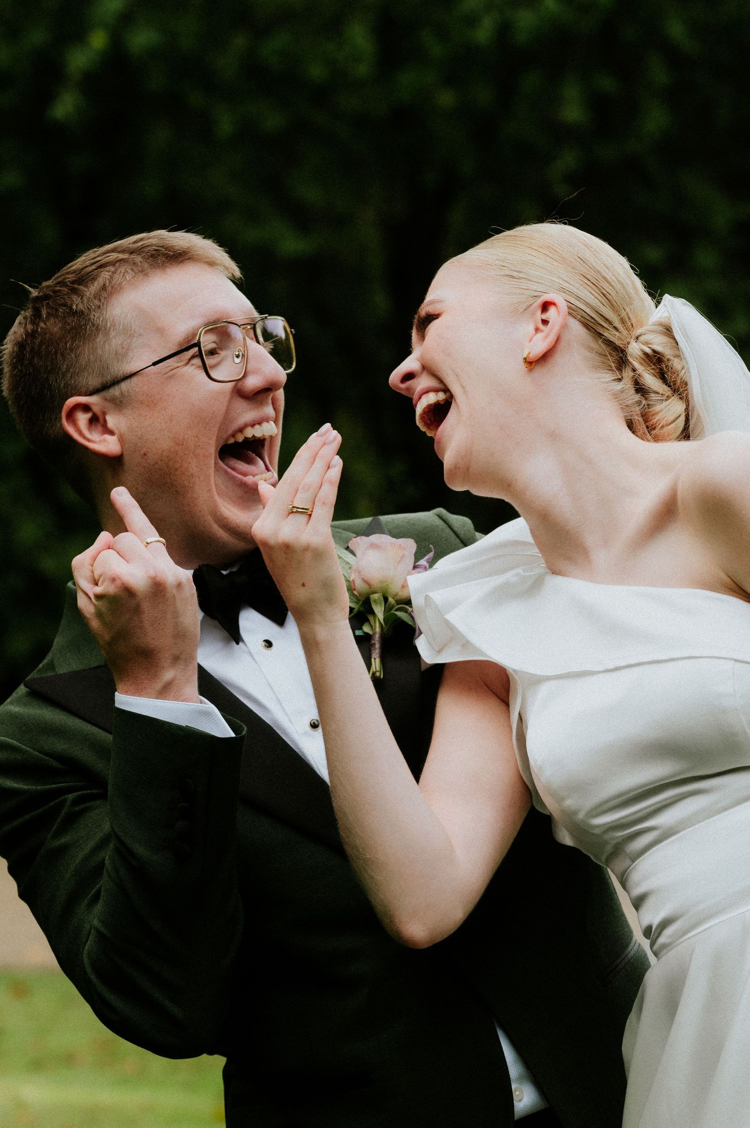 A joyful wedding couple shares laughter during an intimate outdoor moment.
