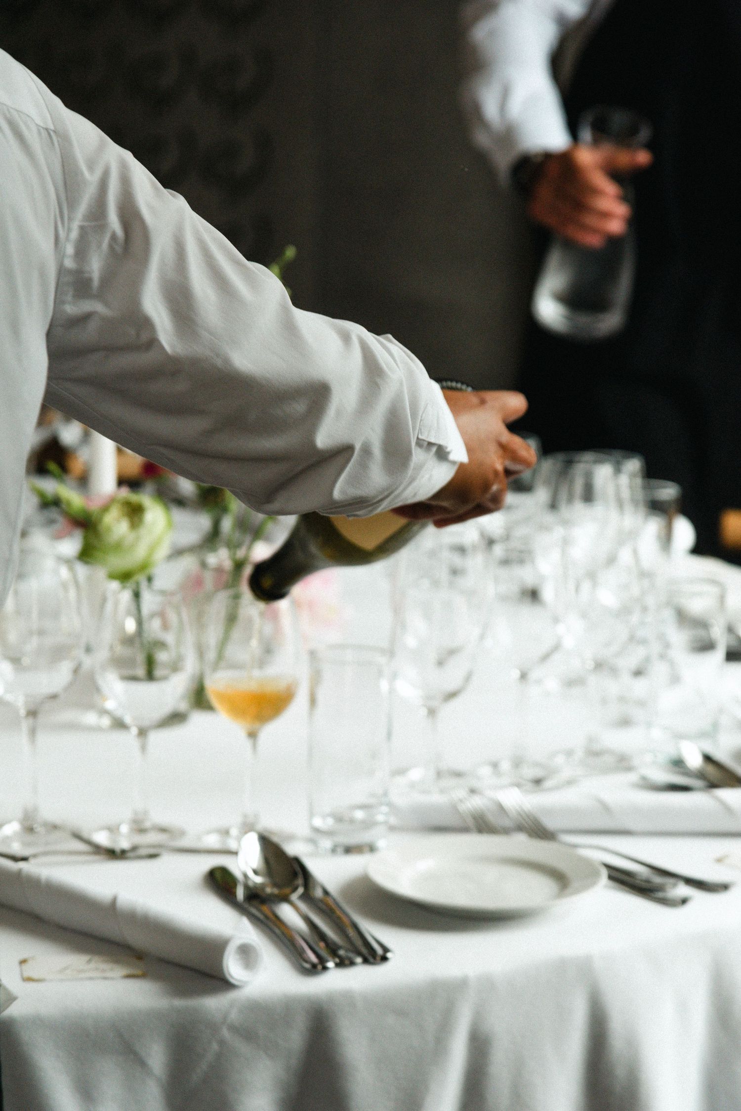 White tablecloth dining setting with wine glasses and place settings at an upscale restaurant.