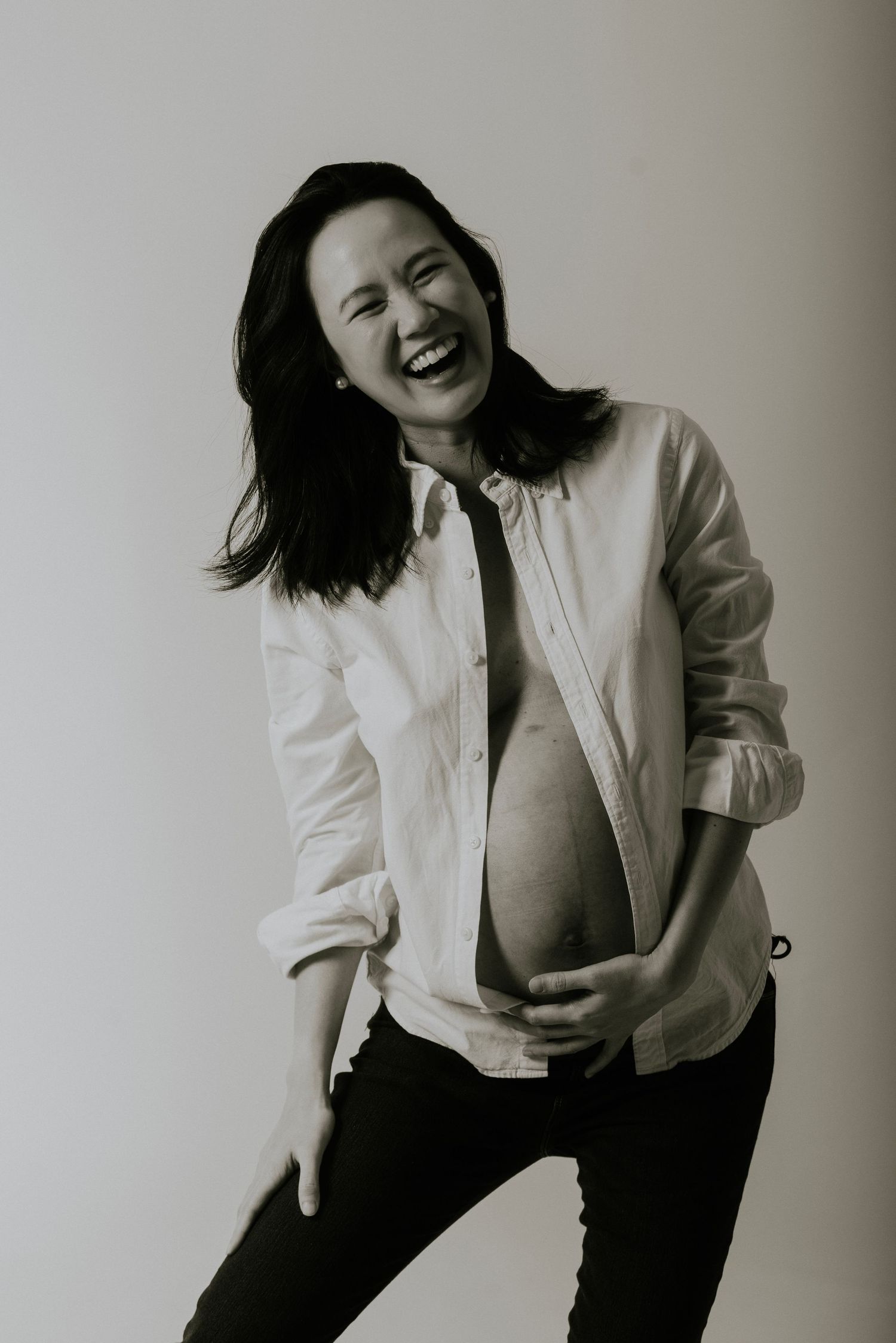Black and white portrait series showing joyful expressions and dynamic poses against a light background.