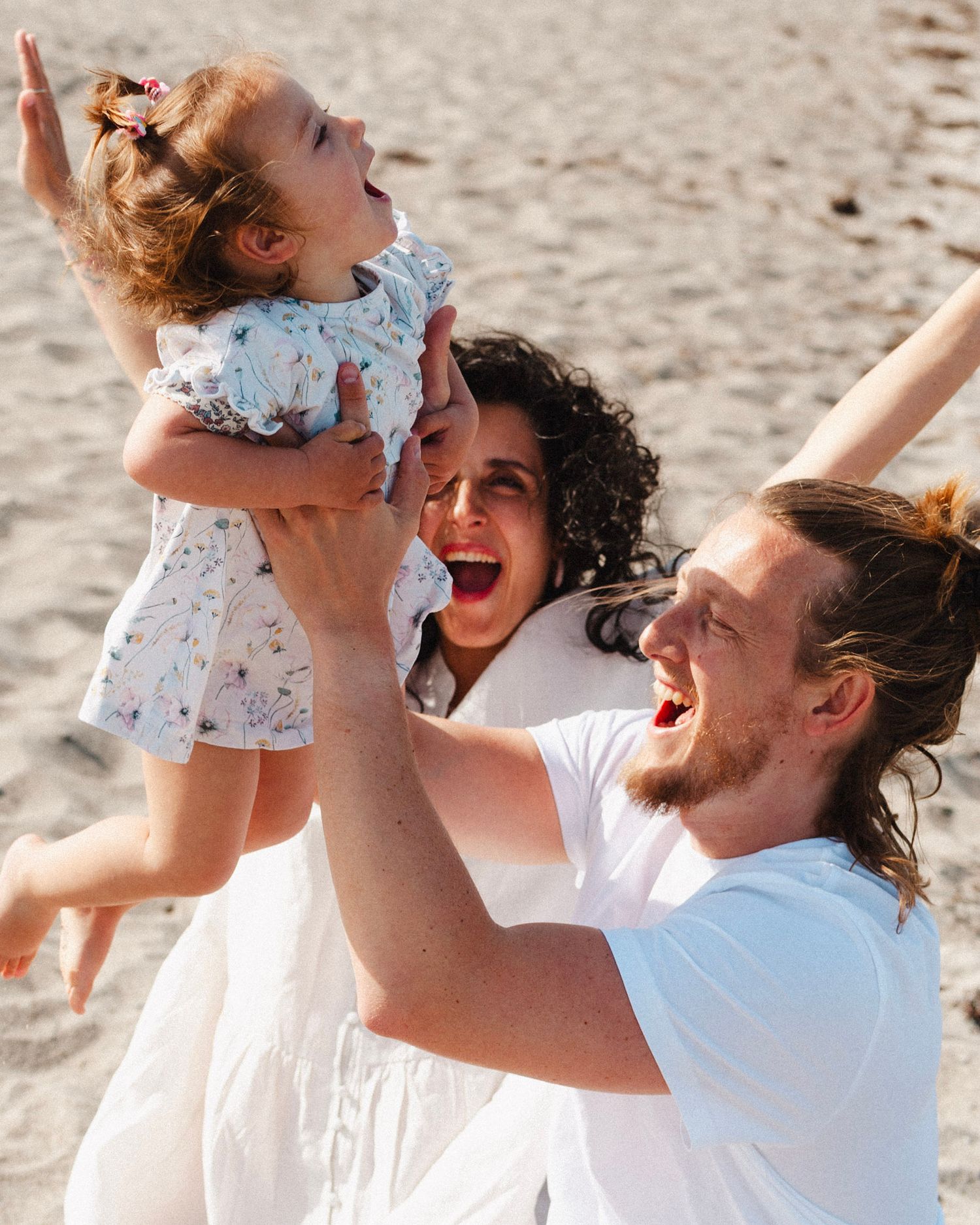 Playful family moment captured in a sequence of joyful interactions on a sunny beach.