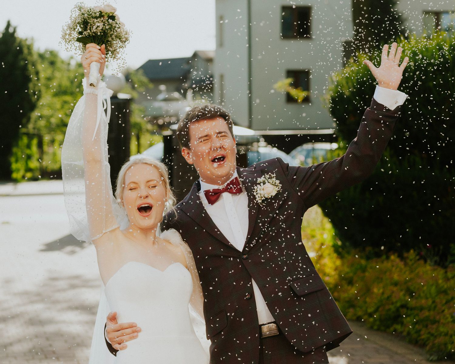 Wedding couple celebrates with confetti in an outdoor celebration.