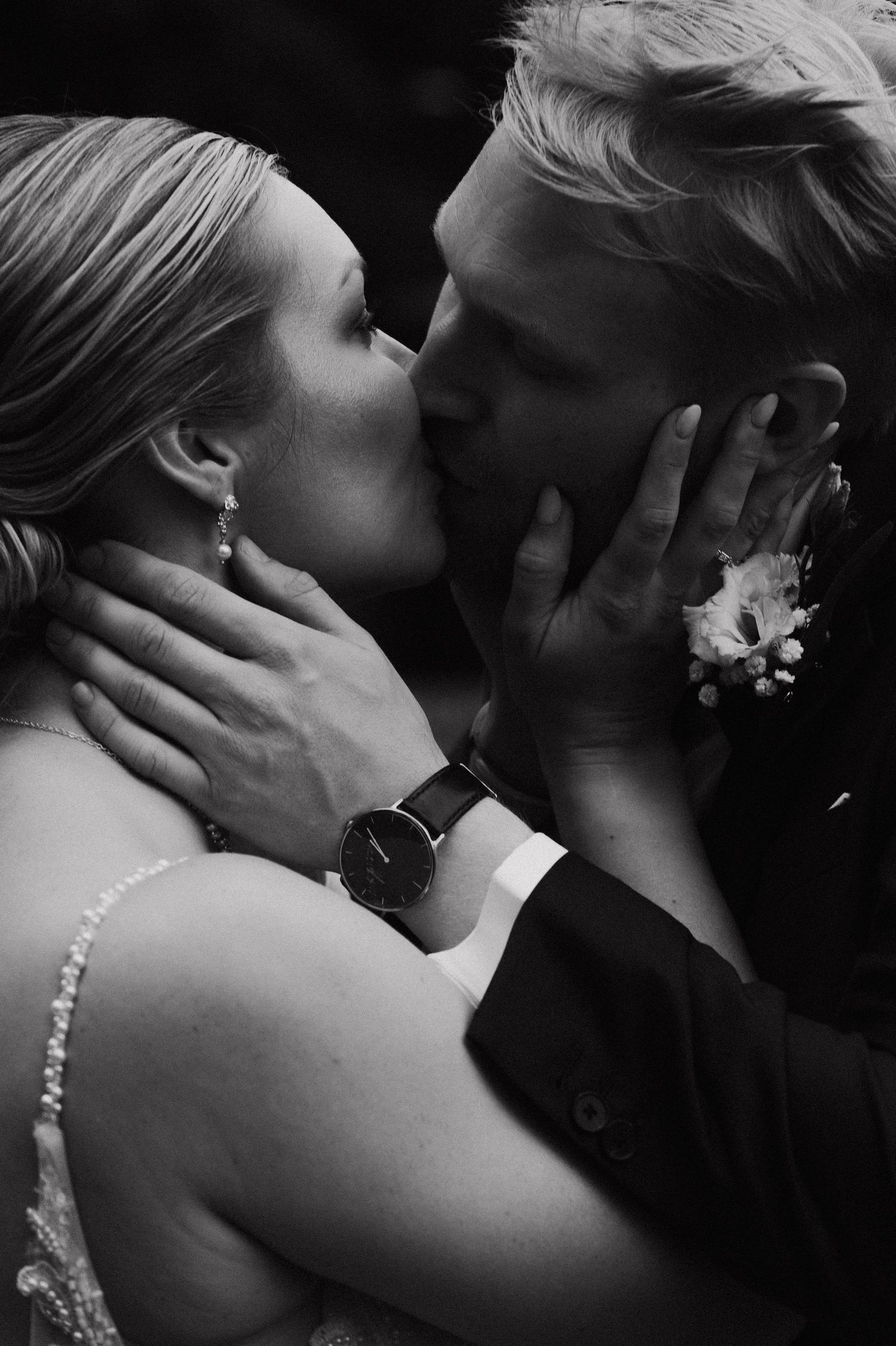 A romantic black and white series of intimate wedding kisses between a couple in formal attire.