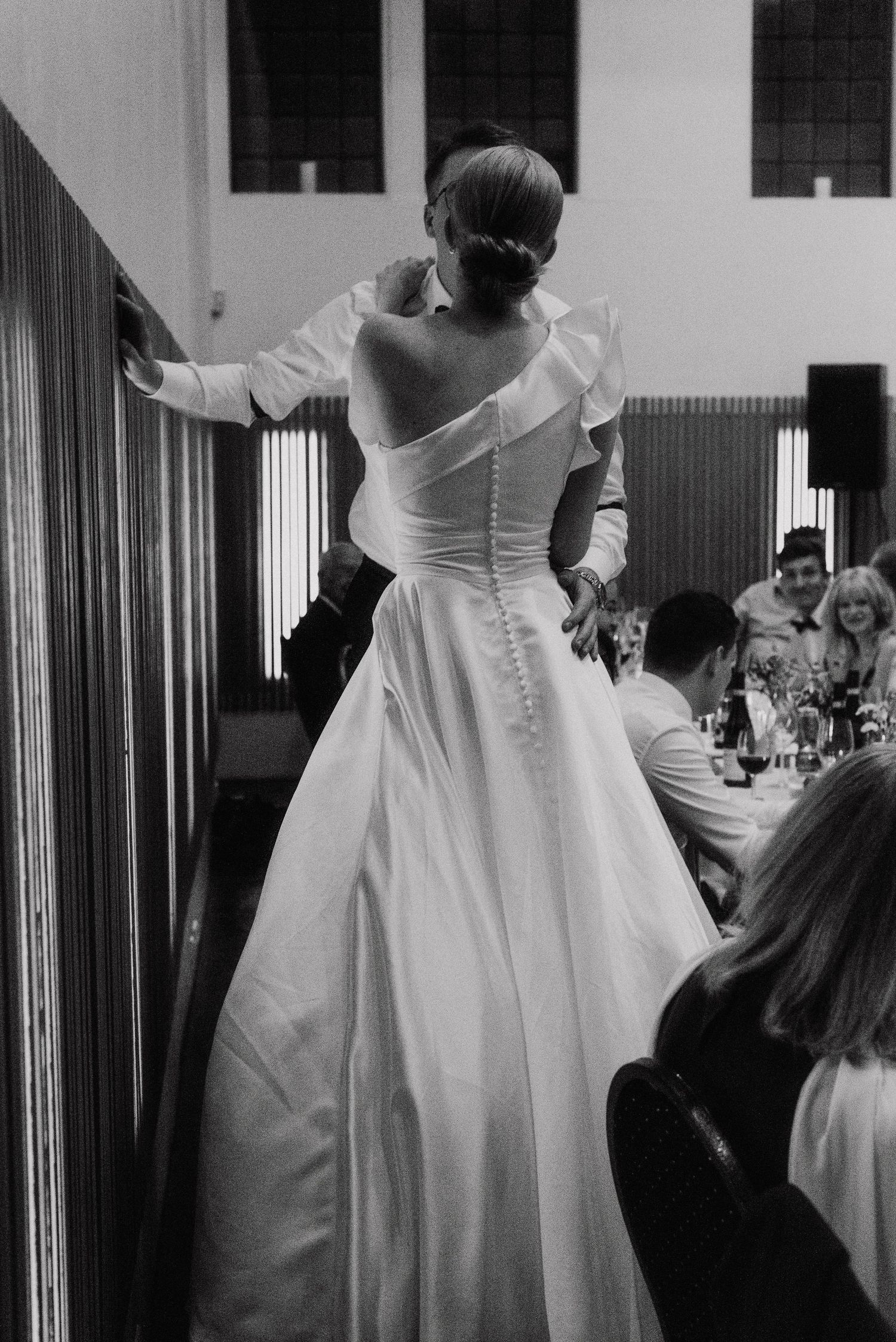 Black and white photo of an elegant wedding dress with ruffled details.
