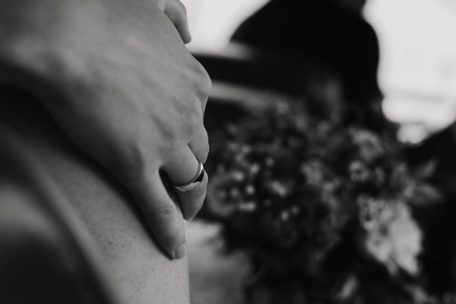 Detail shot of hands holding a rustic wedding bouquet.