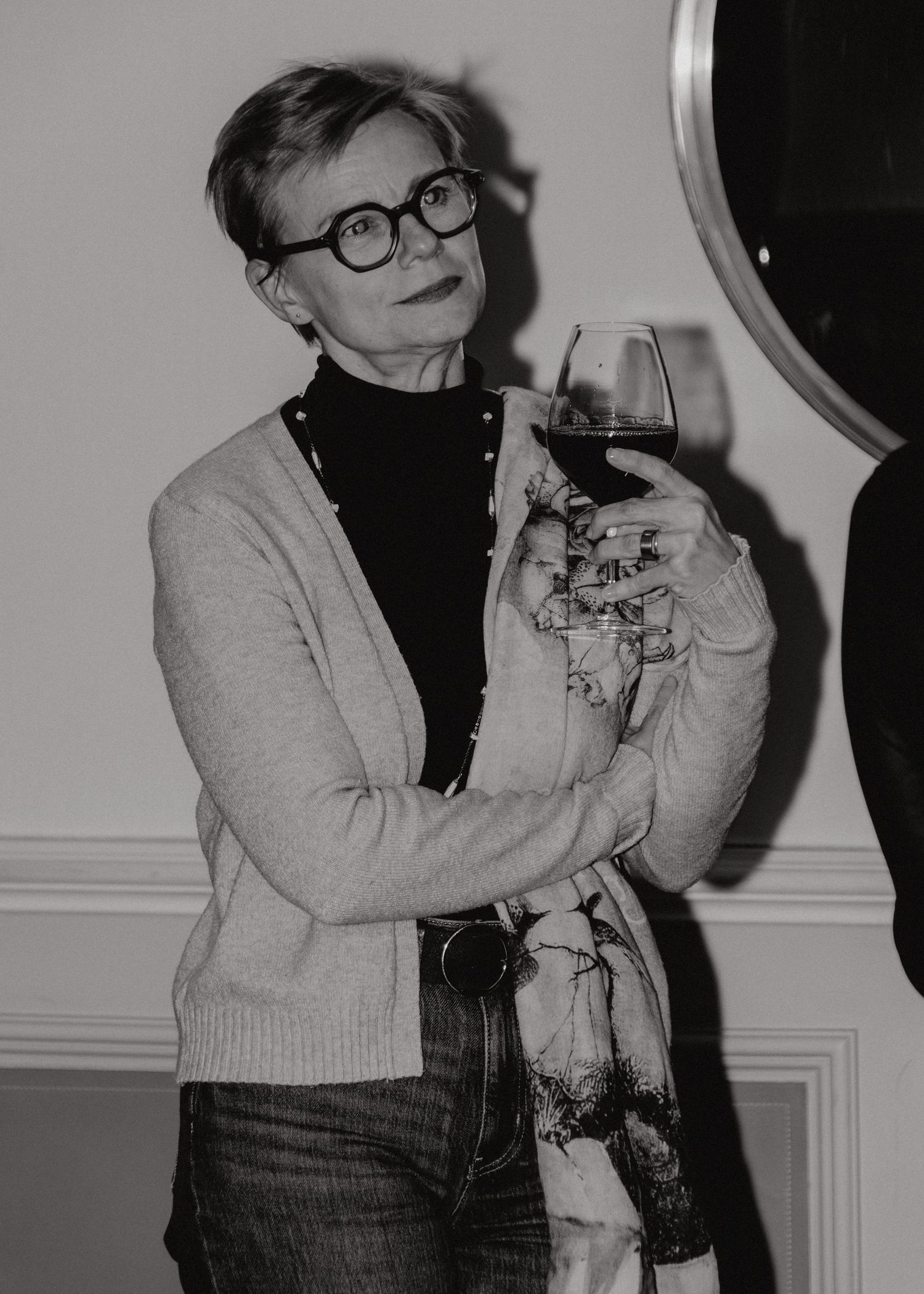A series of black and white photos showing someone in a gray sweater and dark top holding and interacting with a cat.