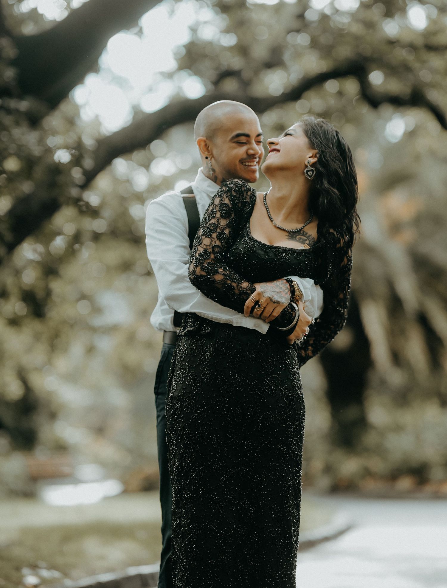 A couple shares a romantic kiss while embracing outdoors in an intimate couples photoshoot setting.
