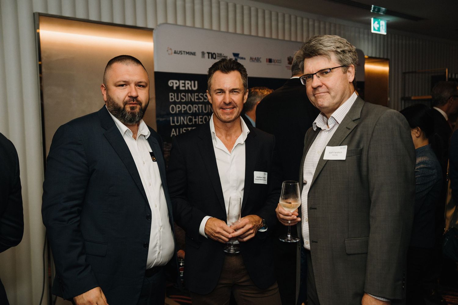 Business professionals networking and socializing at an evening corporate event in a modern venue.
