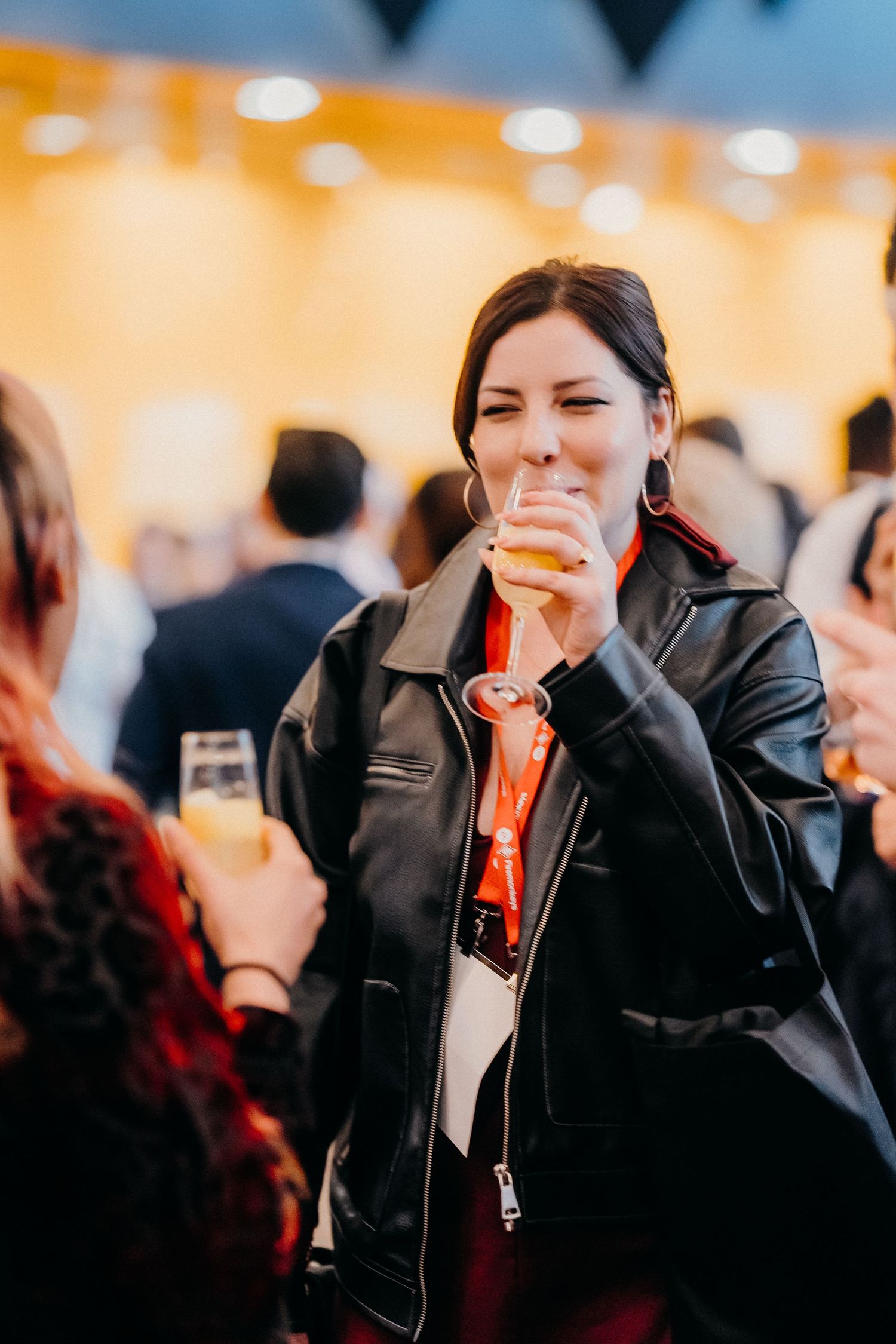 A candid sequence shows someone in a black leather jacket laughing joyfully at a social gathering.
