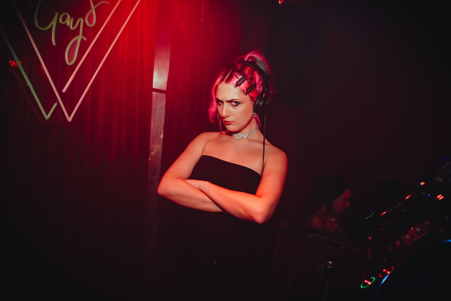A performer in a red outfit performs dramatically on a dimly lit stage with dramatic lighting effects.