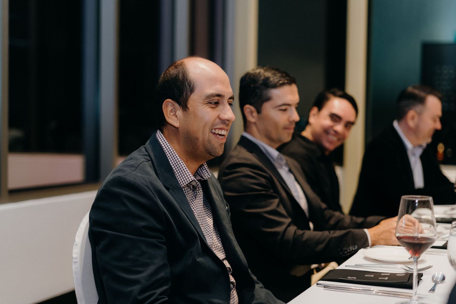 Business professionals sit at a conference table during a corporate meeting.