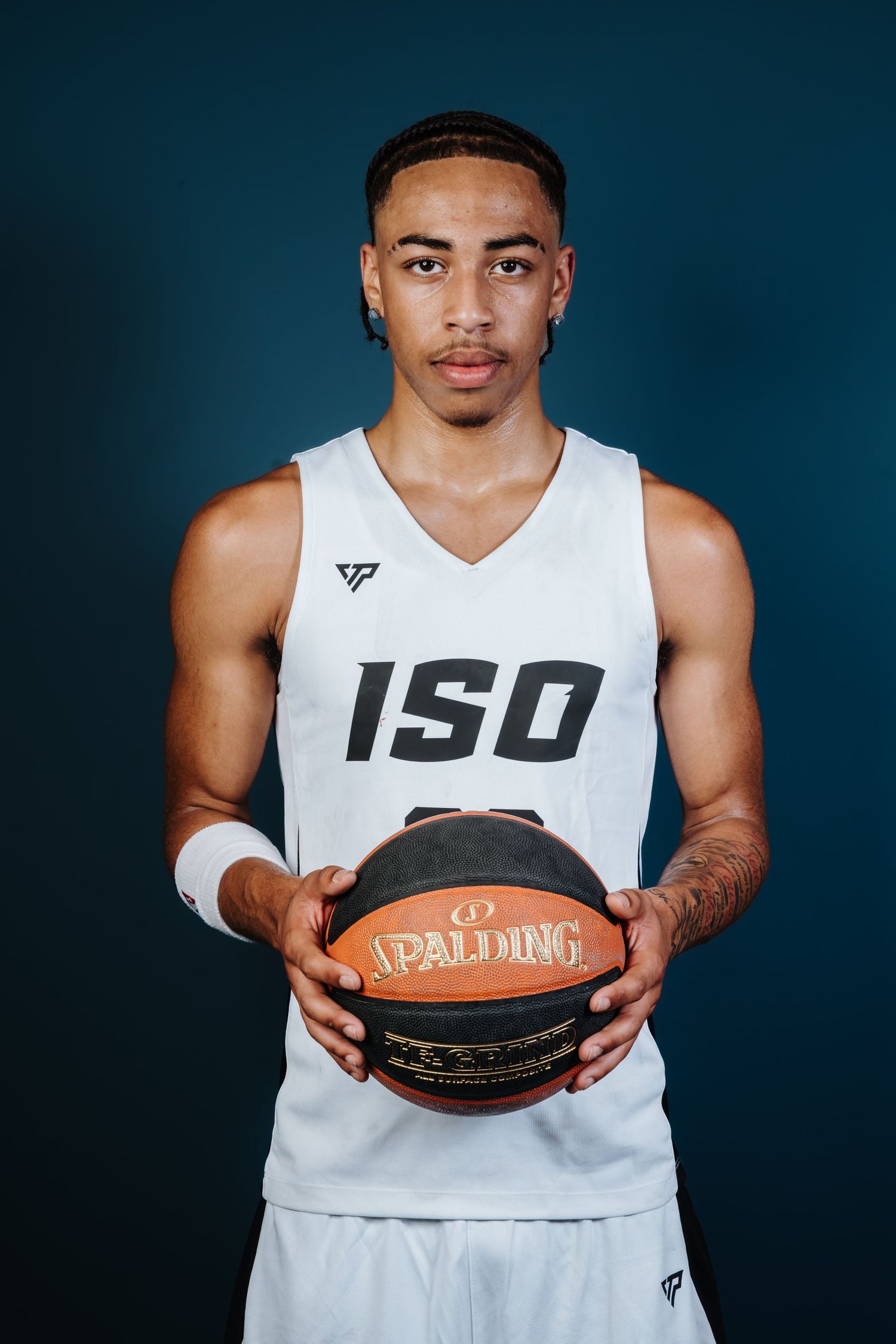 Basketball player in white jersey holds Spalding basketball against dark background in series of cropped shots.