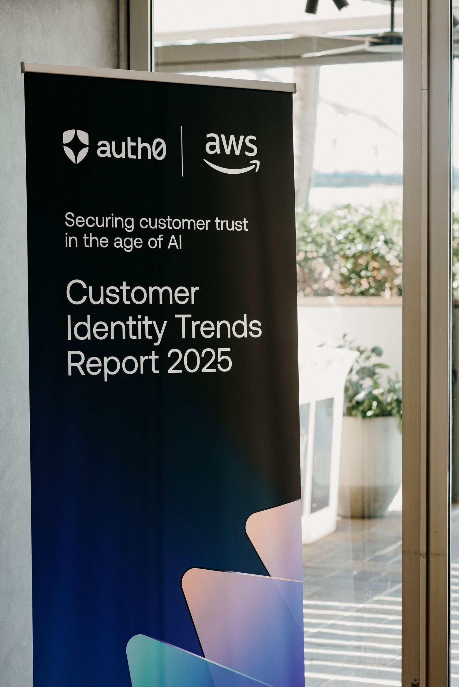 Auth0 and AWS branded identity trends and customer trust report covers displayed in an office setting.