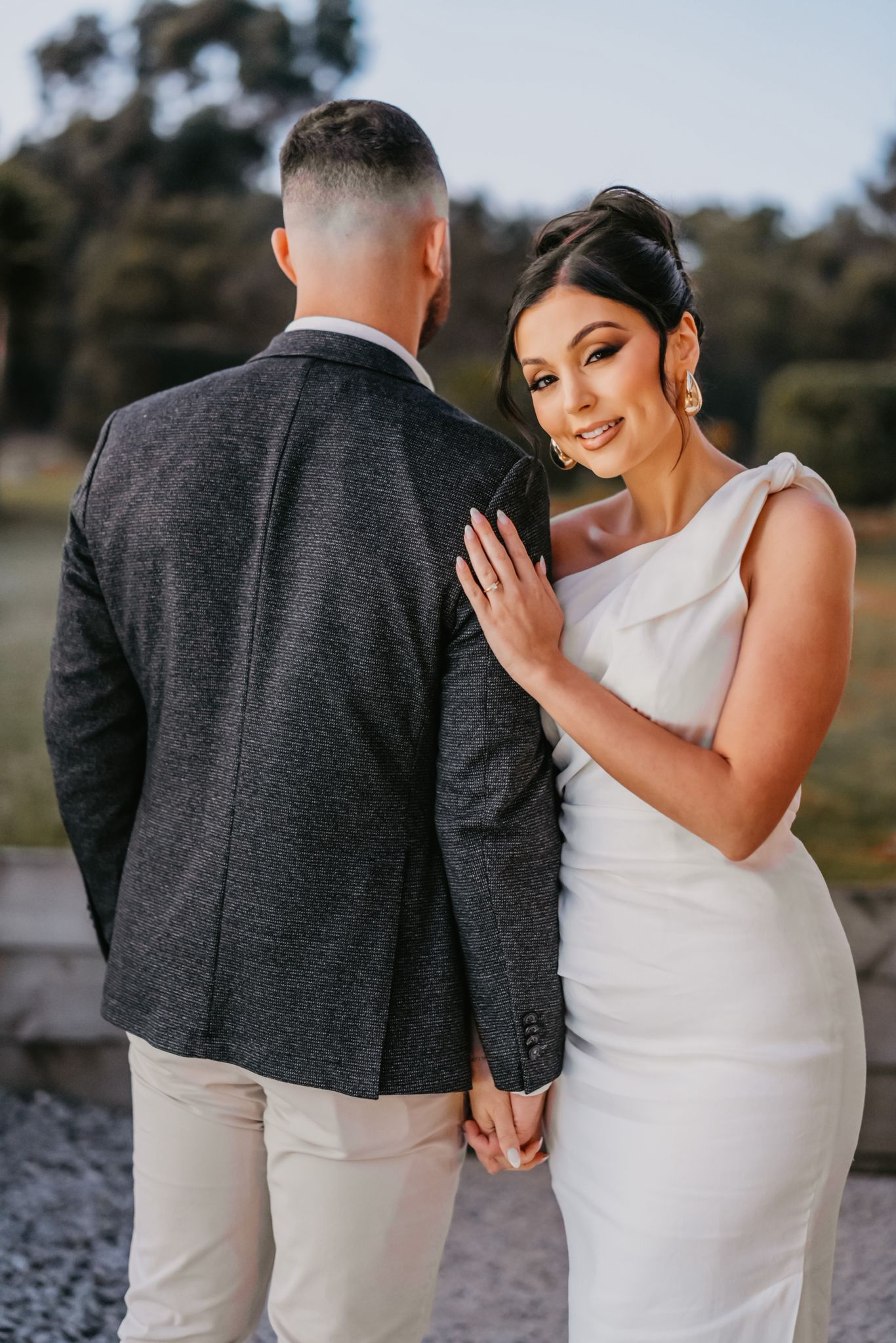 A romantic wedding photoshoot series showing close-up moments between a couple in black and white attire by a lake.