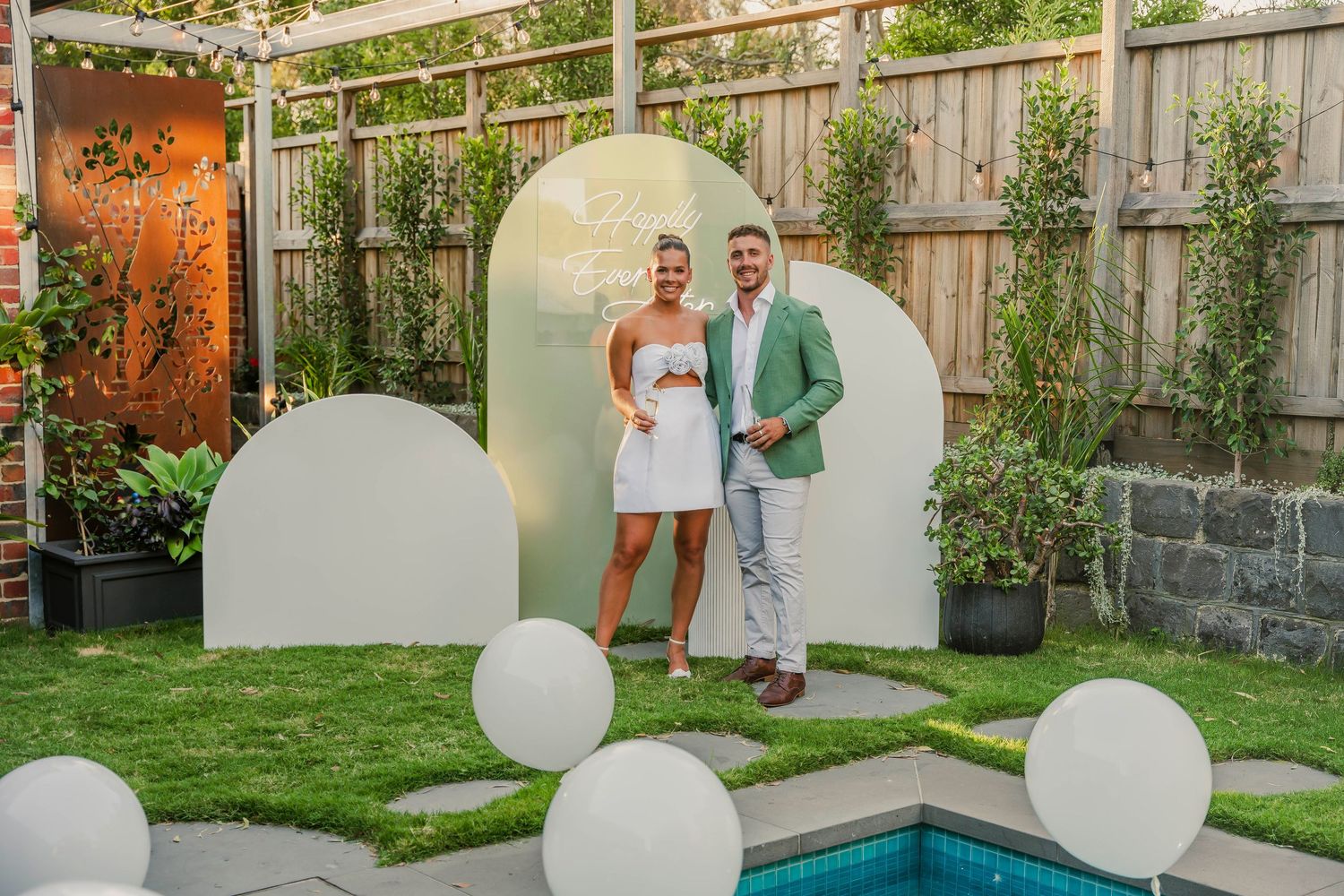 Intimate wedding ceremony celebration with string lights and lemon trees in a backyard garden setting.