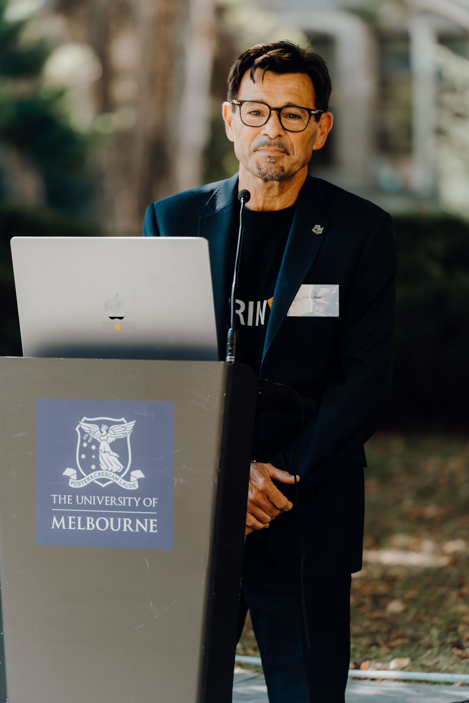 Three images showing a laptop display with the University of Melbourne logo against dark backgrounds during a presentation.
