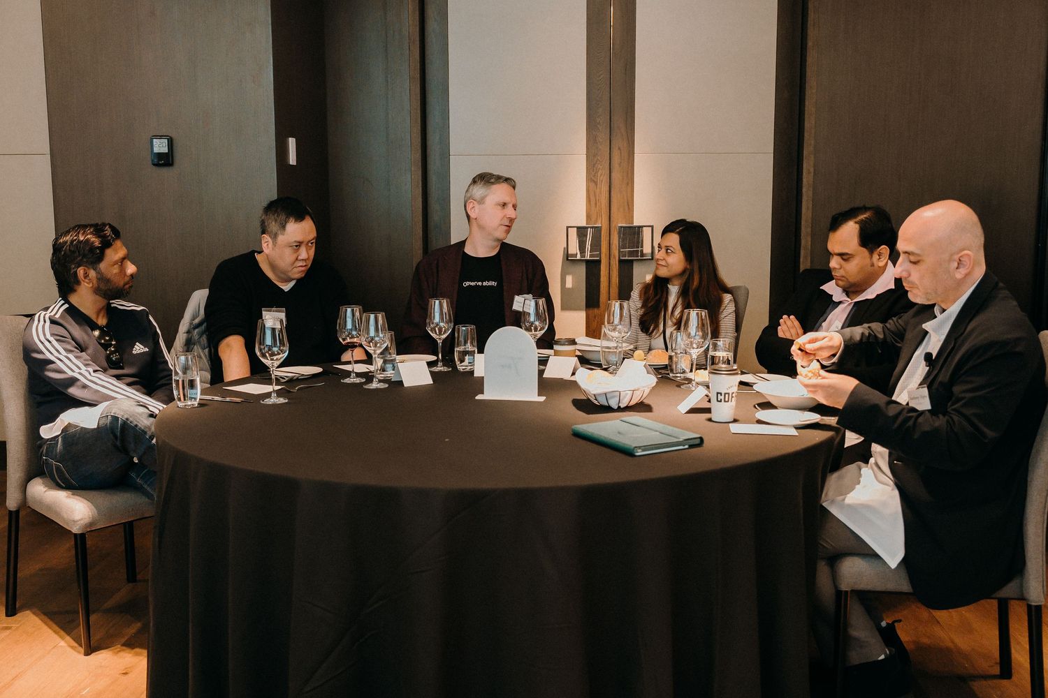 People seated at tables in a modern restaurant interior enjoying dinner service.