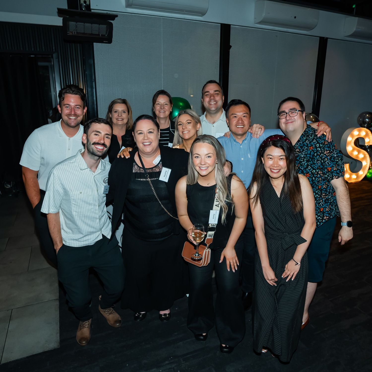 A group of people enjoying themselves at a social gathering in a dimly lit indoor venue.