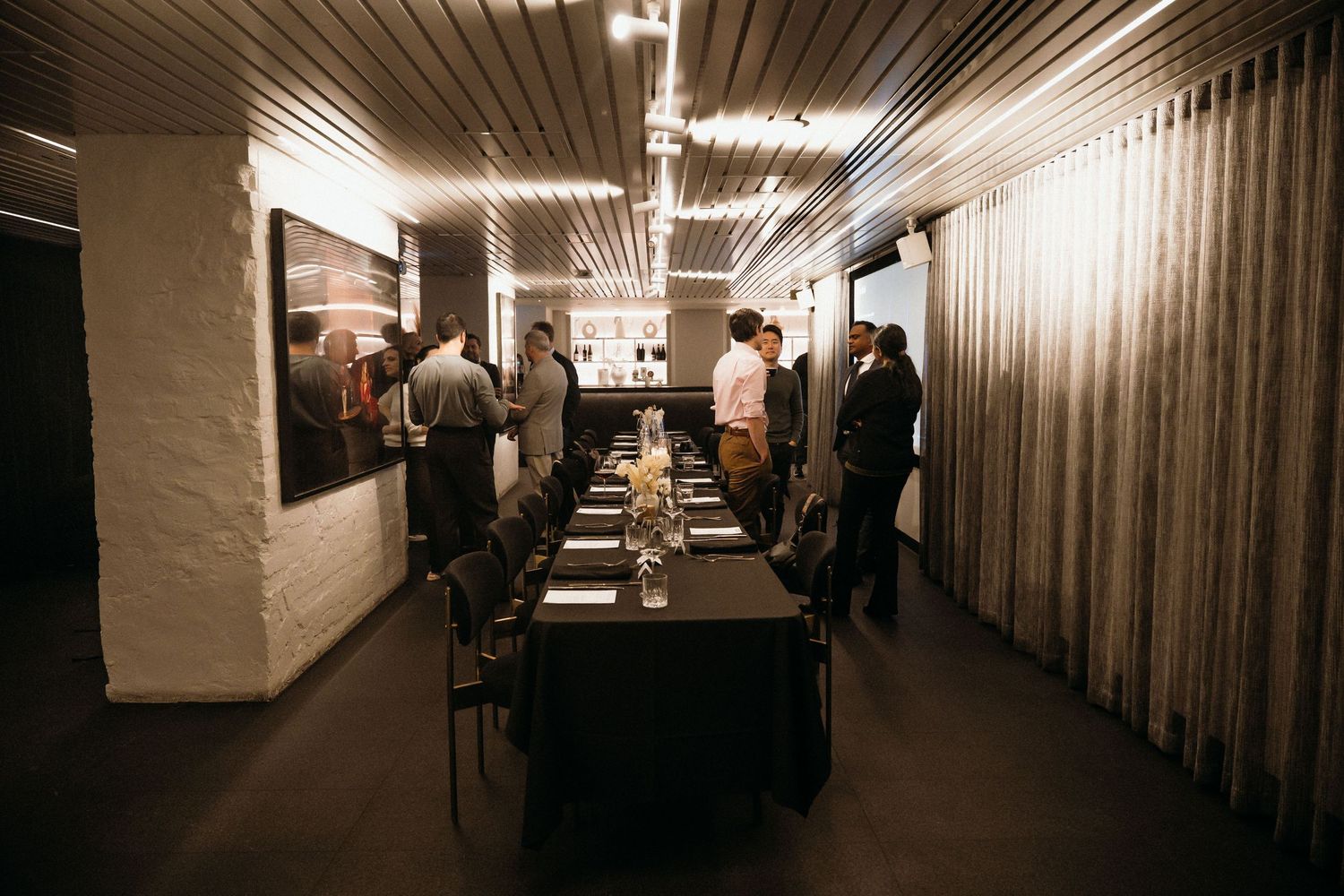 Long dimly lit hallway with corrugated metal walls and fluorescent lighting creating a tunnel-like perspective.