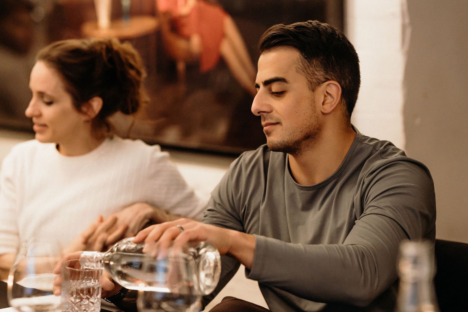 Friends gather around a wooden table at a restaurant for a casual dining experience together.