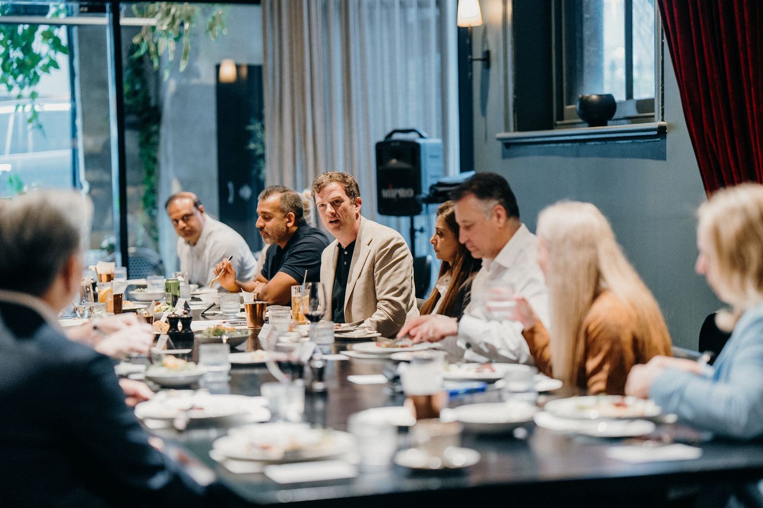 Business professionals collaborate around a conference table during a corporate meeting in a modern office setting.