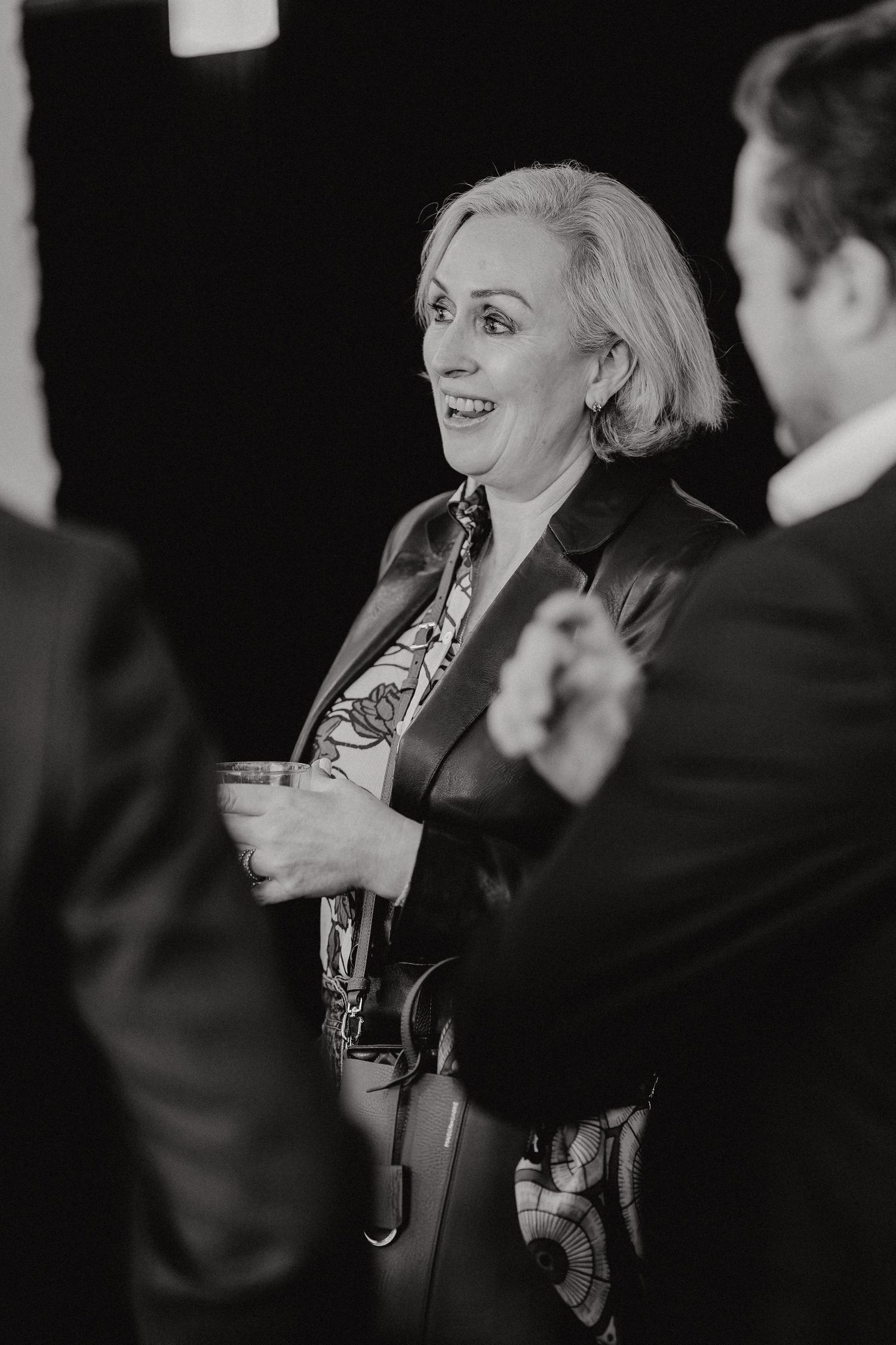 A sequence of black and white photos showing a woman in conversation, laughing and gesturing during an interview.