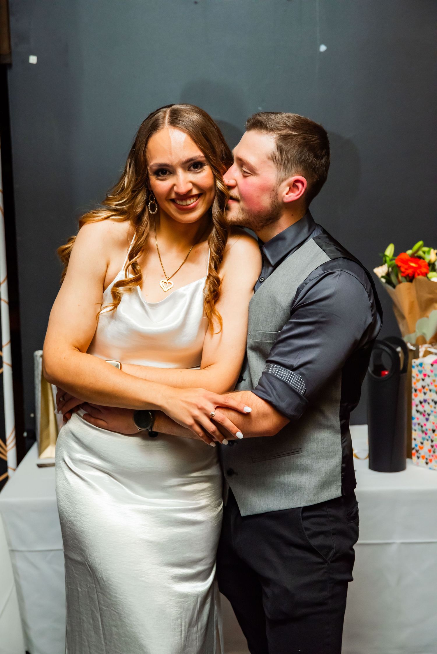 A sequence of candid reception photos showing a couple embracing sweetly at their wedding celebration.