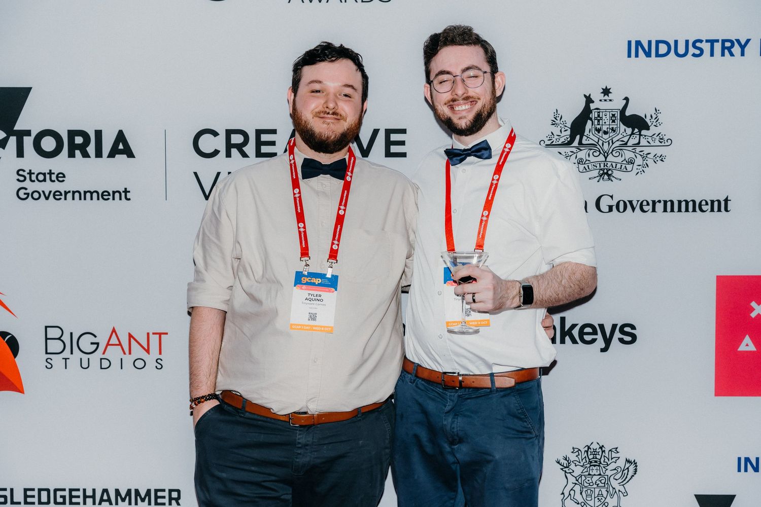 People wearing lanyards and name badges pose together at a business conference or industry event.