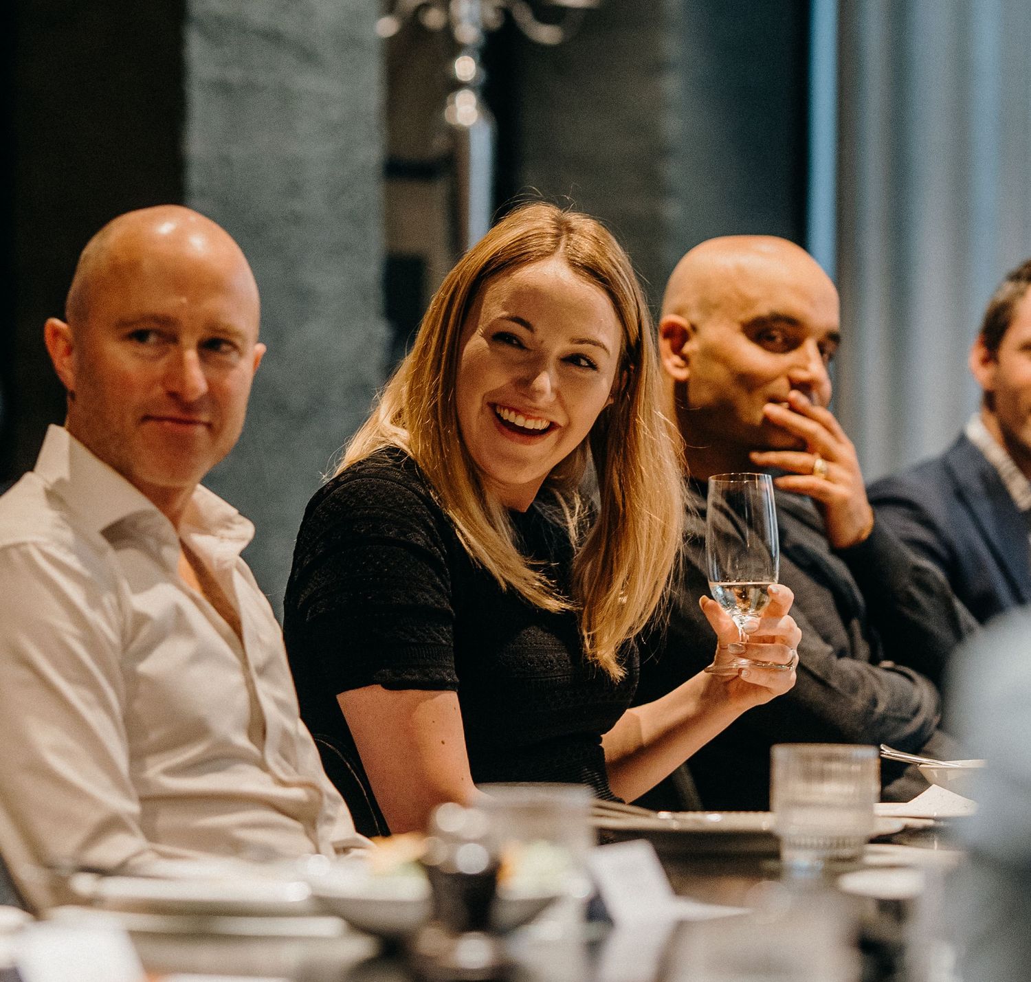 Business colleagues engaged in lively conversation during a meeting at a modern office table.