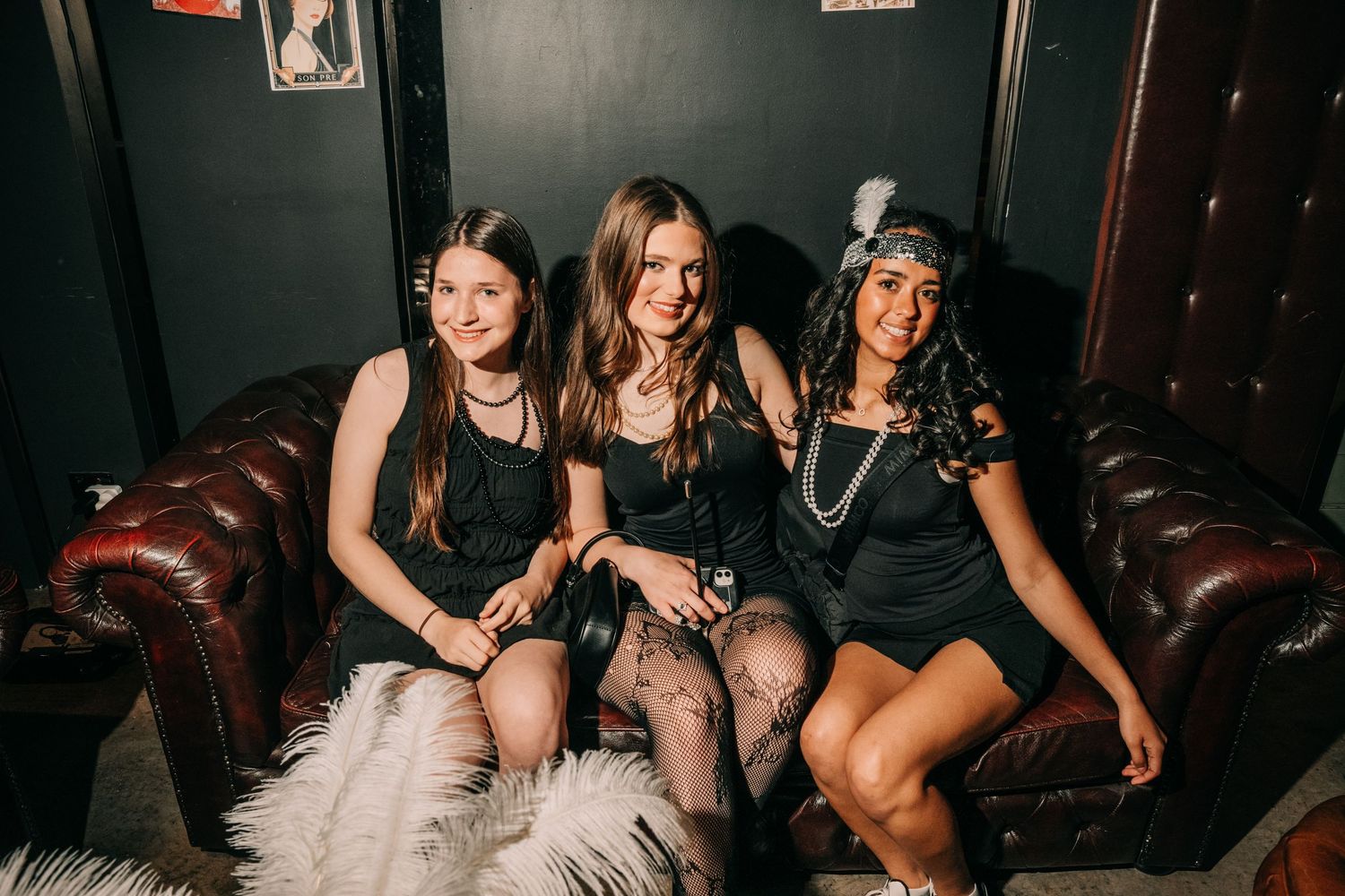 Group of friends having fun and laughing together at a dimly lit nightclub or bar.