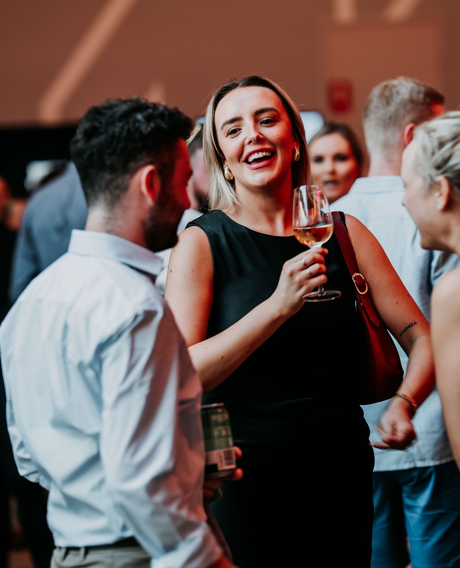 People enjoying drinks and socializing at a lively party or reception event.