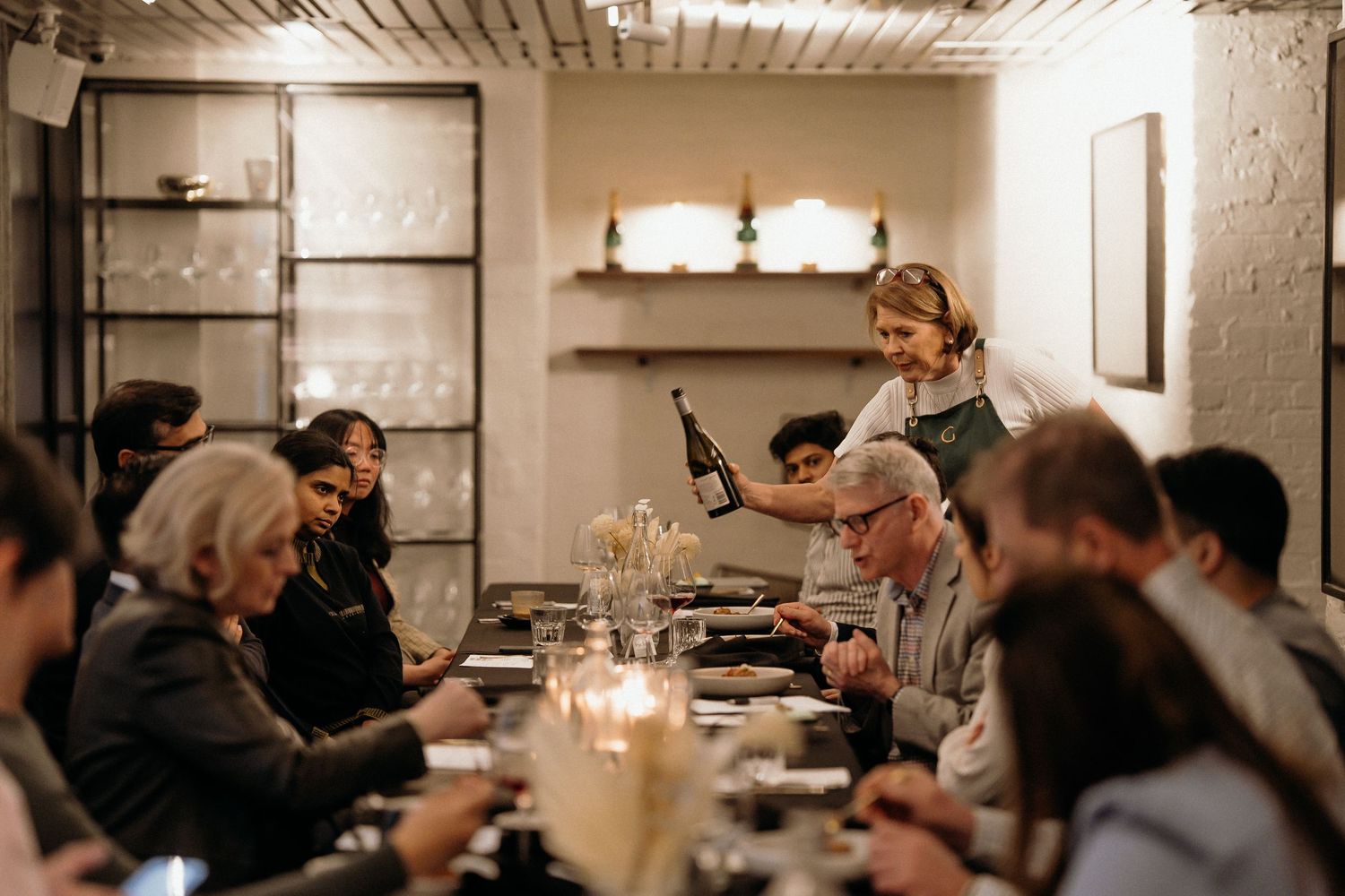 Diners seated at a dimly lit restaurant table with candlelight creating an intimate ambiance.