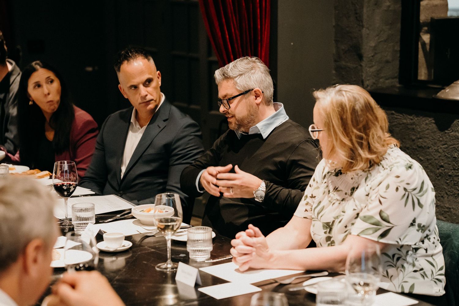 Business professionals collaborate and engage in discussion during a meeting at a conference table.