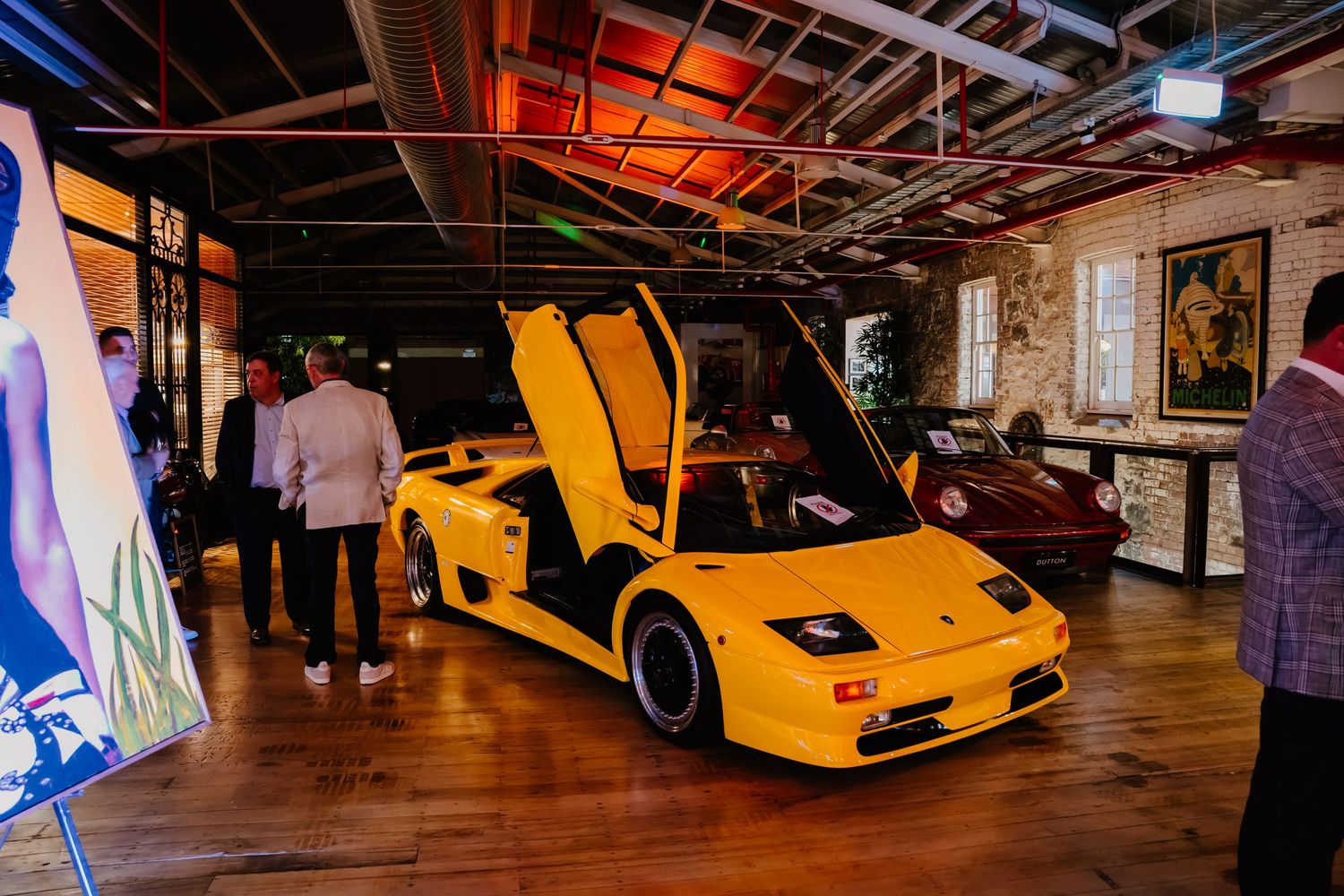 Yellow high-performance sports cars on display in a dimly lit automotive showroom with exhibition lighting.