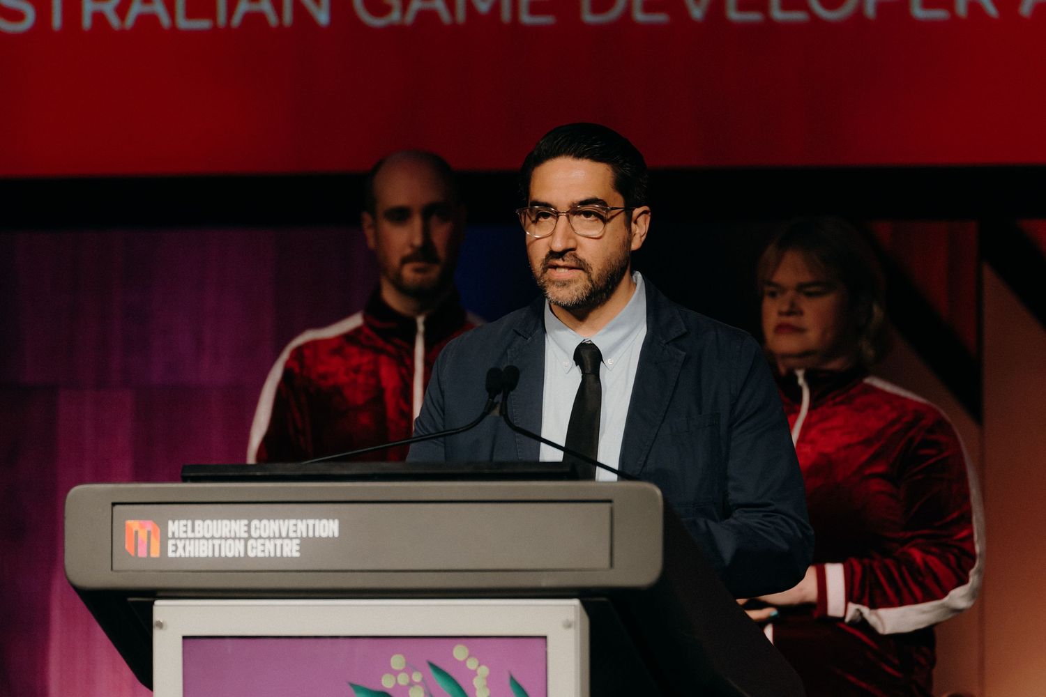 A series of presentation slides and banners from a game developer conference with red and dark backgrounds.