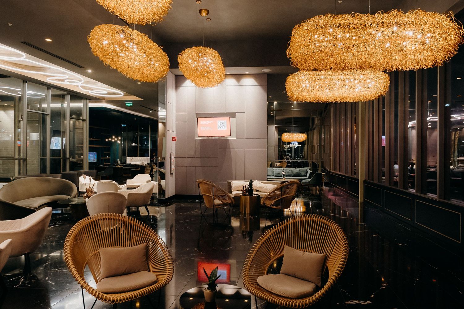 Modern restaurant interior with warm lighting from woven pendant lamps and comfortable brown seating arrangements.