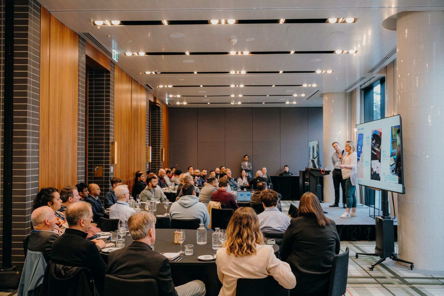 Business professionals gathered in a modern conference room with bright lighting and sleek decor for a meeting.