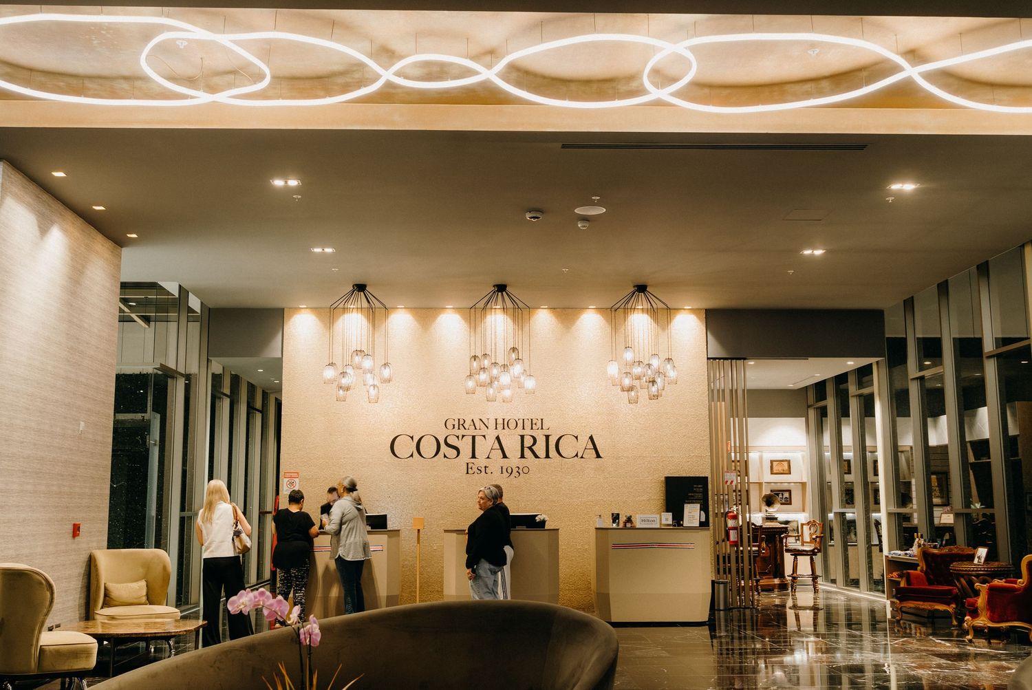 Modern hotel lobby interior with white walls, pendant lighting fixtures and sleek minimalist design elements.