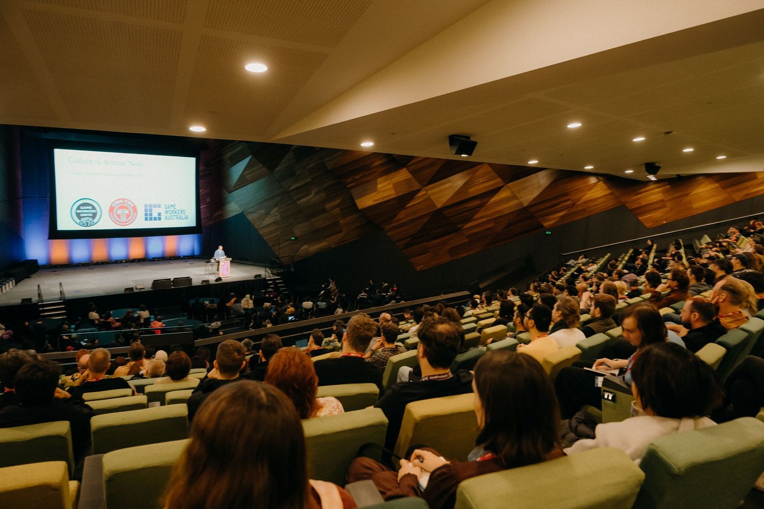 Students seated in a large lecture hall during a presentation or class session.