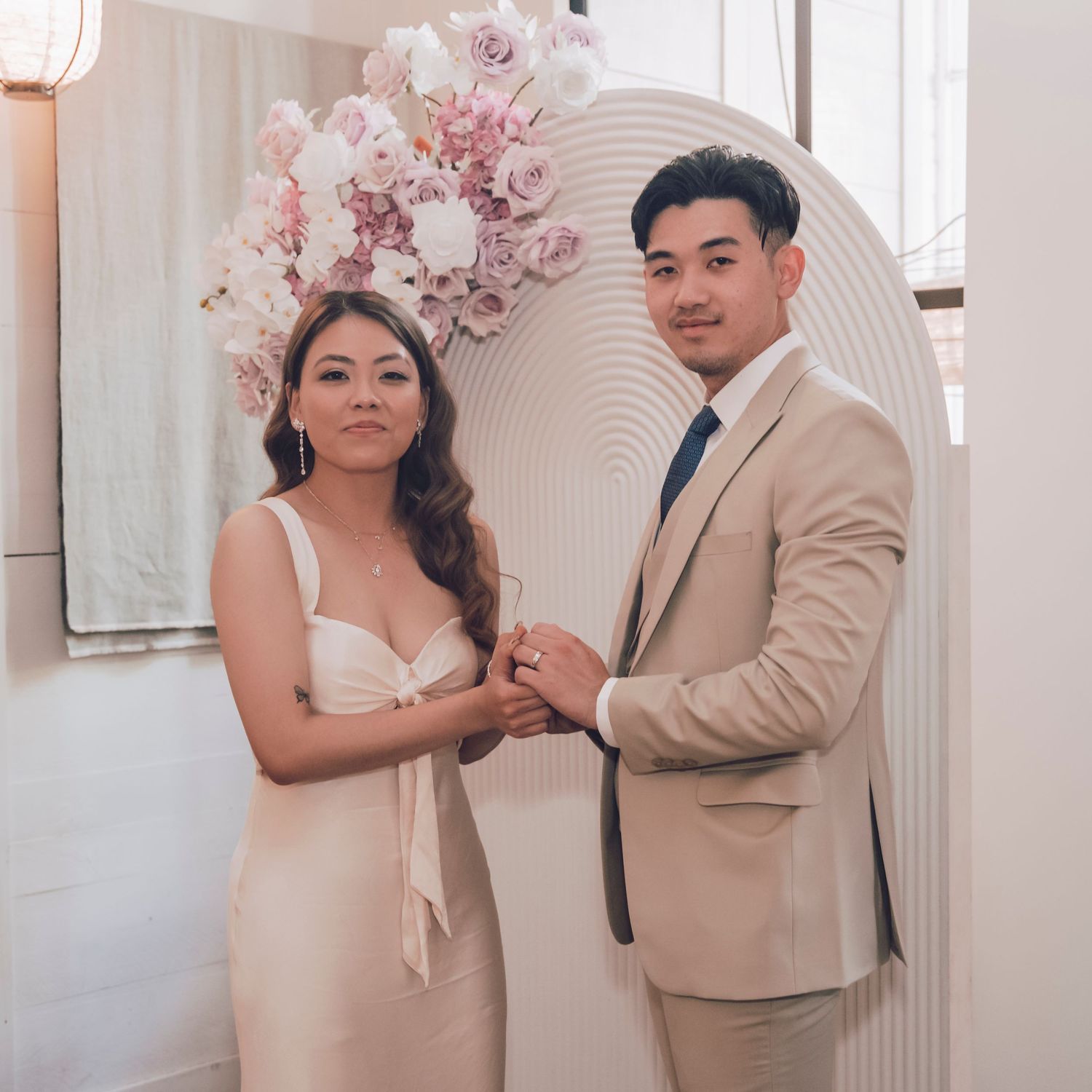 A tender wedding moment captured in a series of romantic, muted pastel images with the couple and pink floral decor.