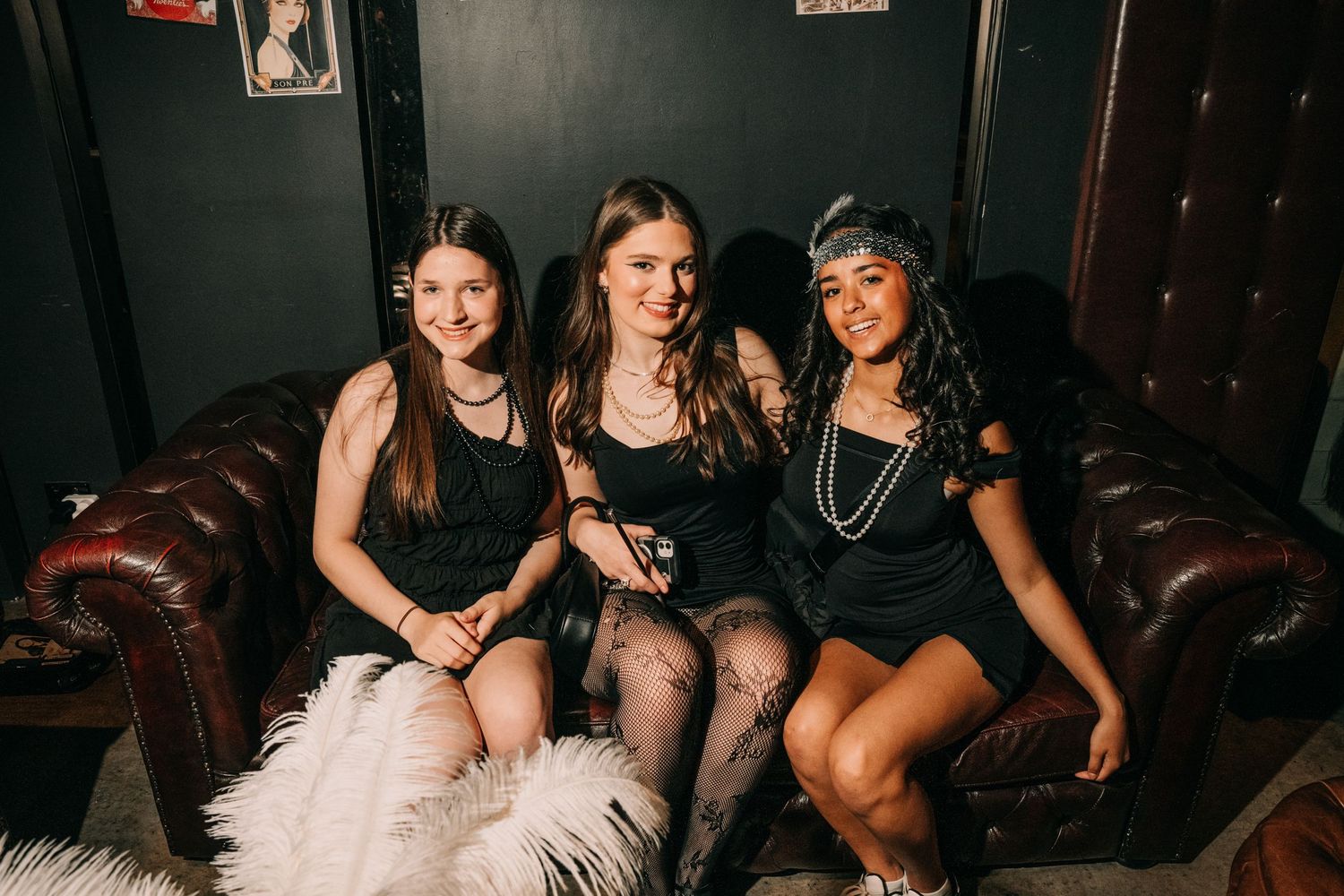 A group of friends enjoying drinks and socializing at a dimly lit bar or nightclub setting.