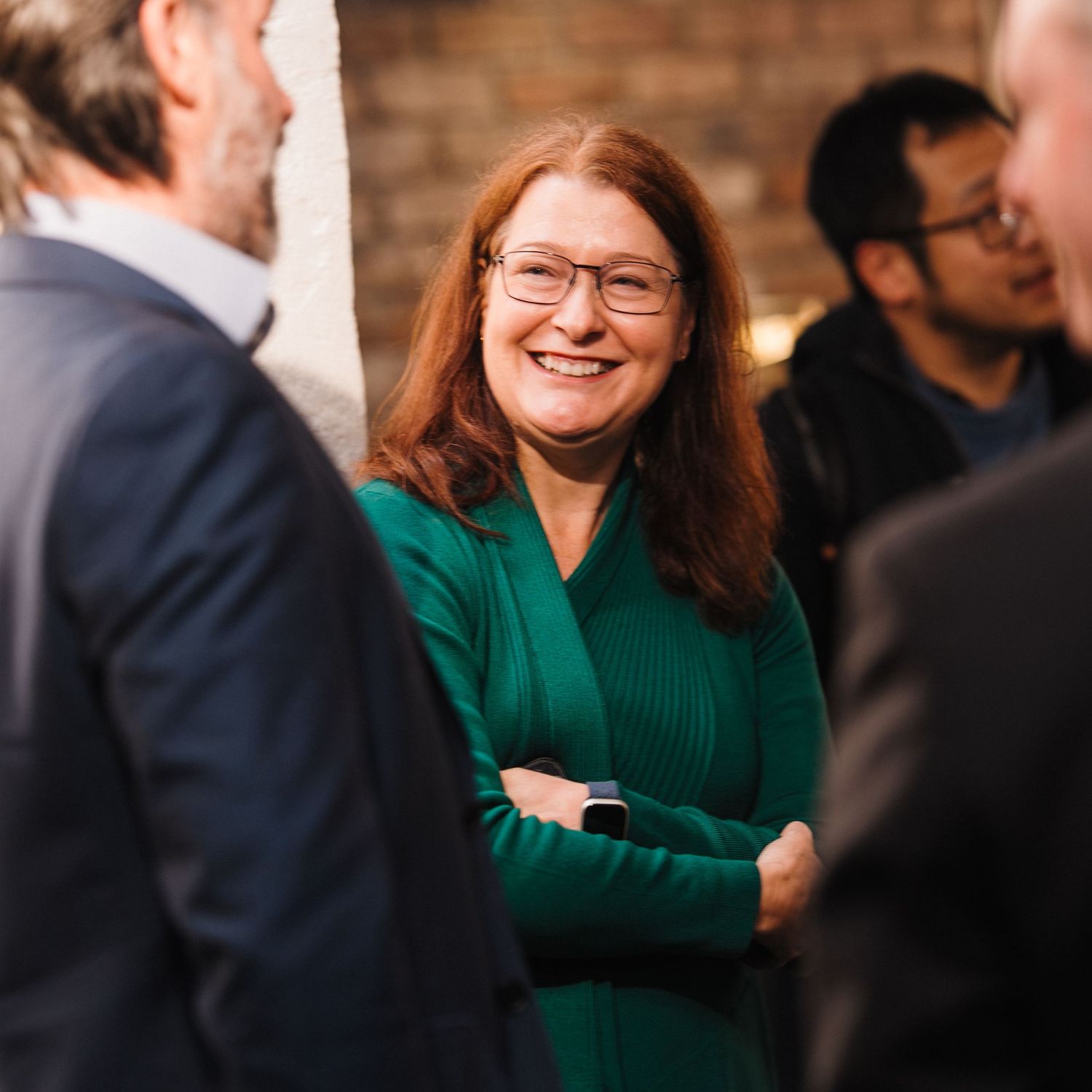 A series of candid moments showing people in conversation at a professional gathering, with warm lighting and blurred backgrounds.