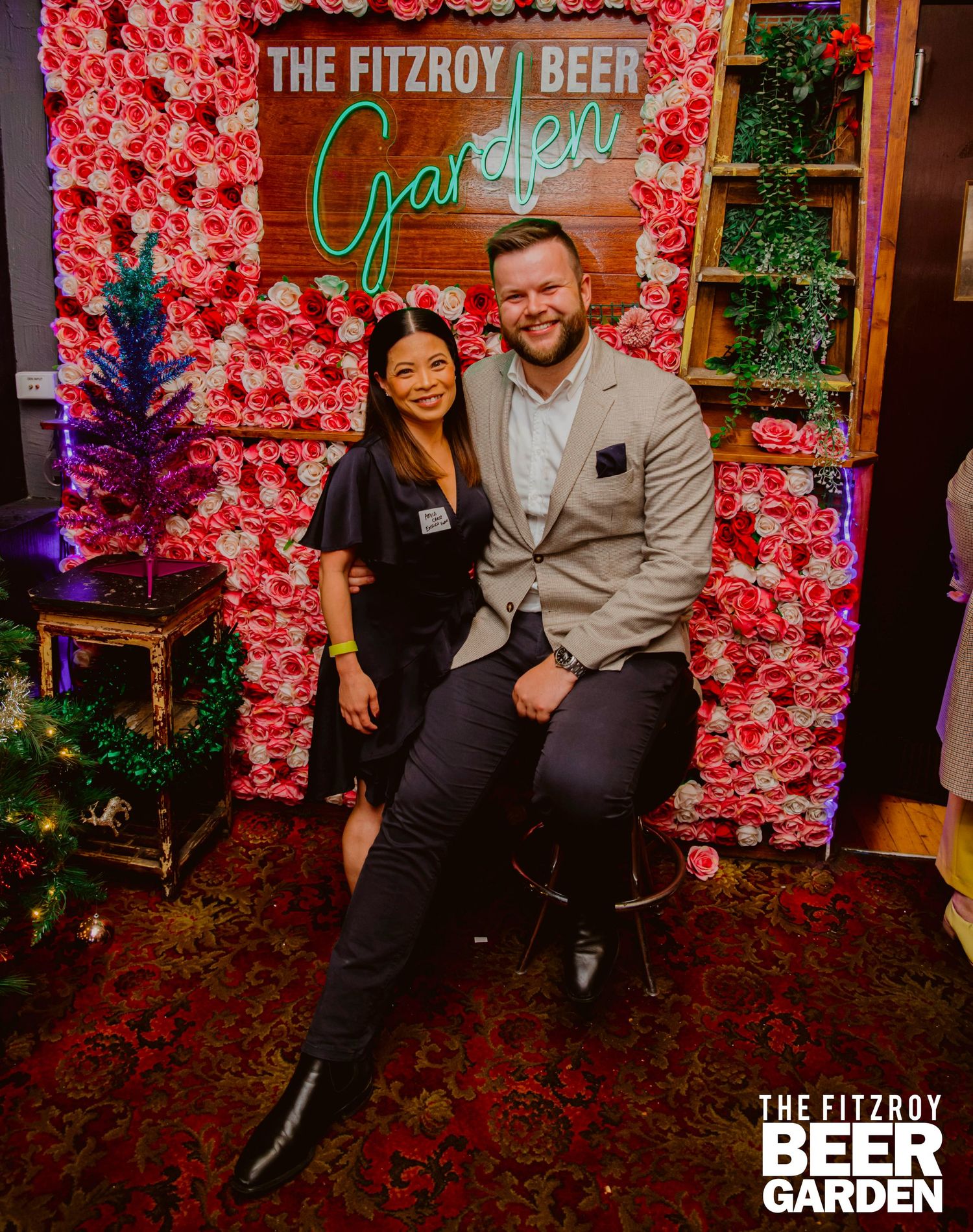 Pink floral wall backdrop with neon garden sign creates an inviting atmosphere at The Fitzroy Beer Garden event space.