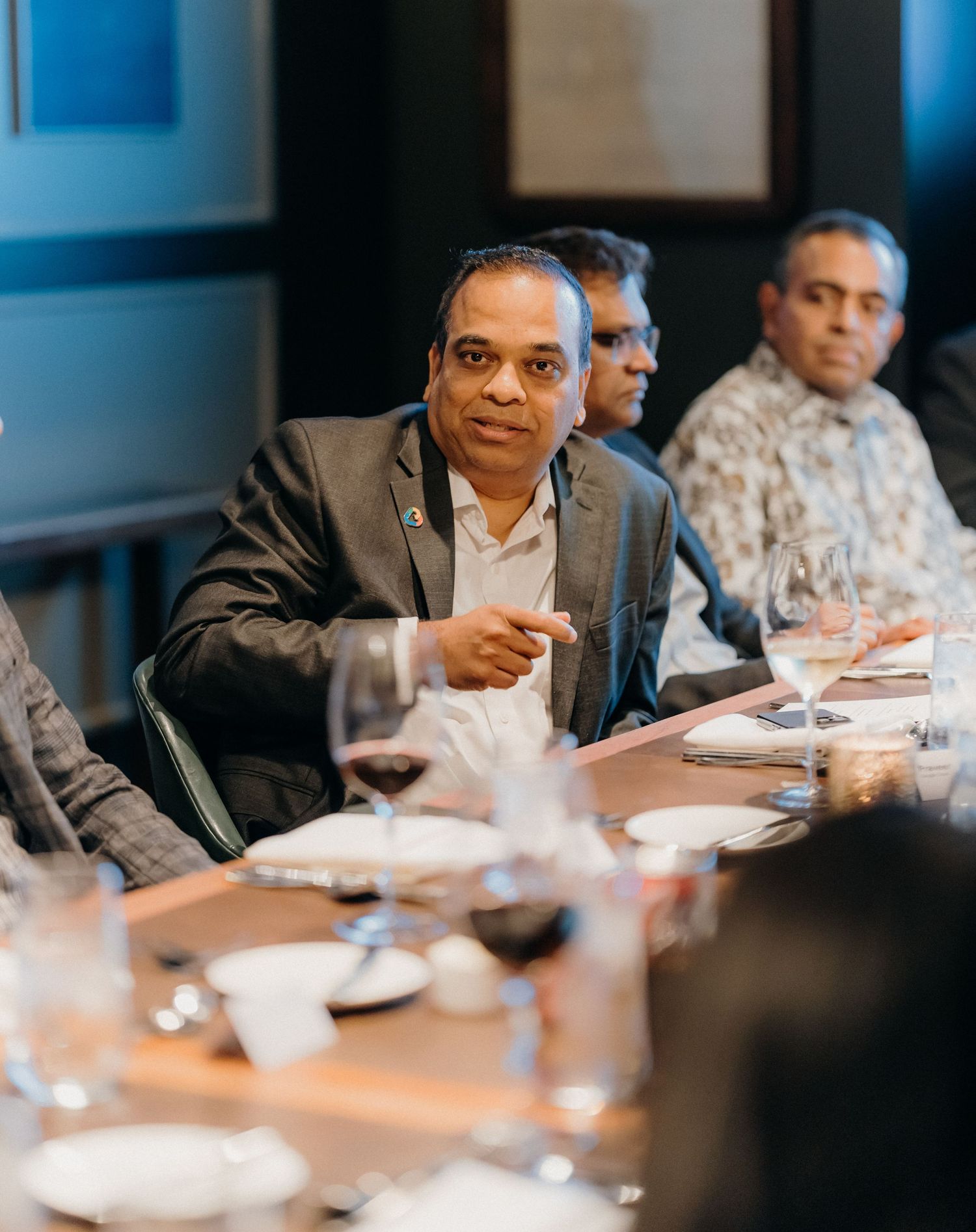 Business professionals sitting at a conference table during a meeting in a modern office setting.